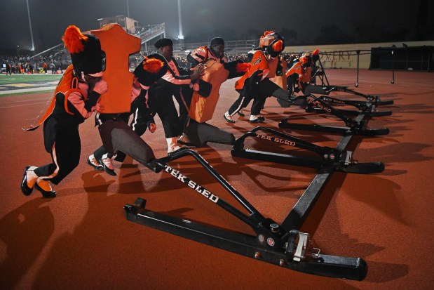 Members of the Pittsburg Marching Show Band push a blocking sled out of the way before their performance during the CIF NorCal Division 1-A Championship game at Pittsburg High School in Pittsburg, Calif., on Saturday, Dec. 6, 2025. Central East defeats Pittsburg 55-36. (Jose Carlos Fajardo/Bay Area News Group)