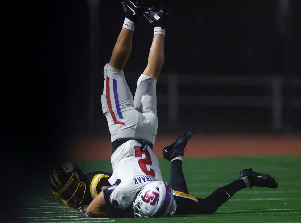 St. Ignatius' Luke Van De Braak (2) falls head first with the ball over Ventura's Jack Cunningham (3) in the second quarter during Division 3-AA state championship football game at Fullerton Union High School District Stadium in Fullerton, Calif., on Friday, Dec. 12, 2025. (Shae Hammond/Bay Area News Group)