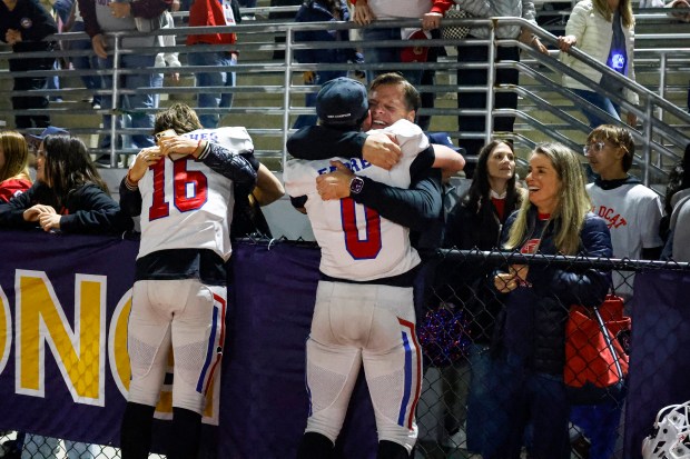 St. Ignatius' James Hughes (16) and St. Ignatius' Jack Farrell (0) hug family after St. Ignatius won against Ventura during the Division 3-AA state championship football game at Fullerton Union High School District Stadium in Fullerton, Calif., on Friday, Dec. 12, 2025. (Shae Hammond/Bay Area News Group)
