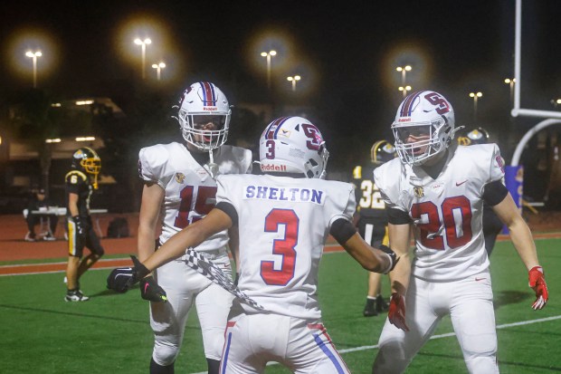 St. Ignatius' Zui Shelton (3) celebrates scoring a touchdown with St. Ignatius' Jake Batchelder (15) and St. Ignatius' Hawkes Packard (20) against Ventura in the third quarter during Division 3-AA state championship football game at Fullerton Union High School District Stadium in Fullerton, Calif., on Friday, Dec. 12, 2025. (Shae Hammond/Bay Area News Group)