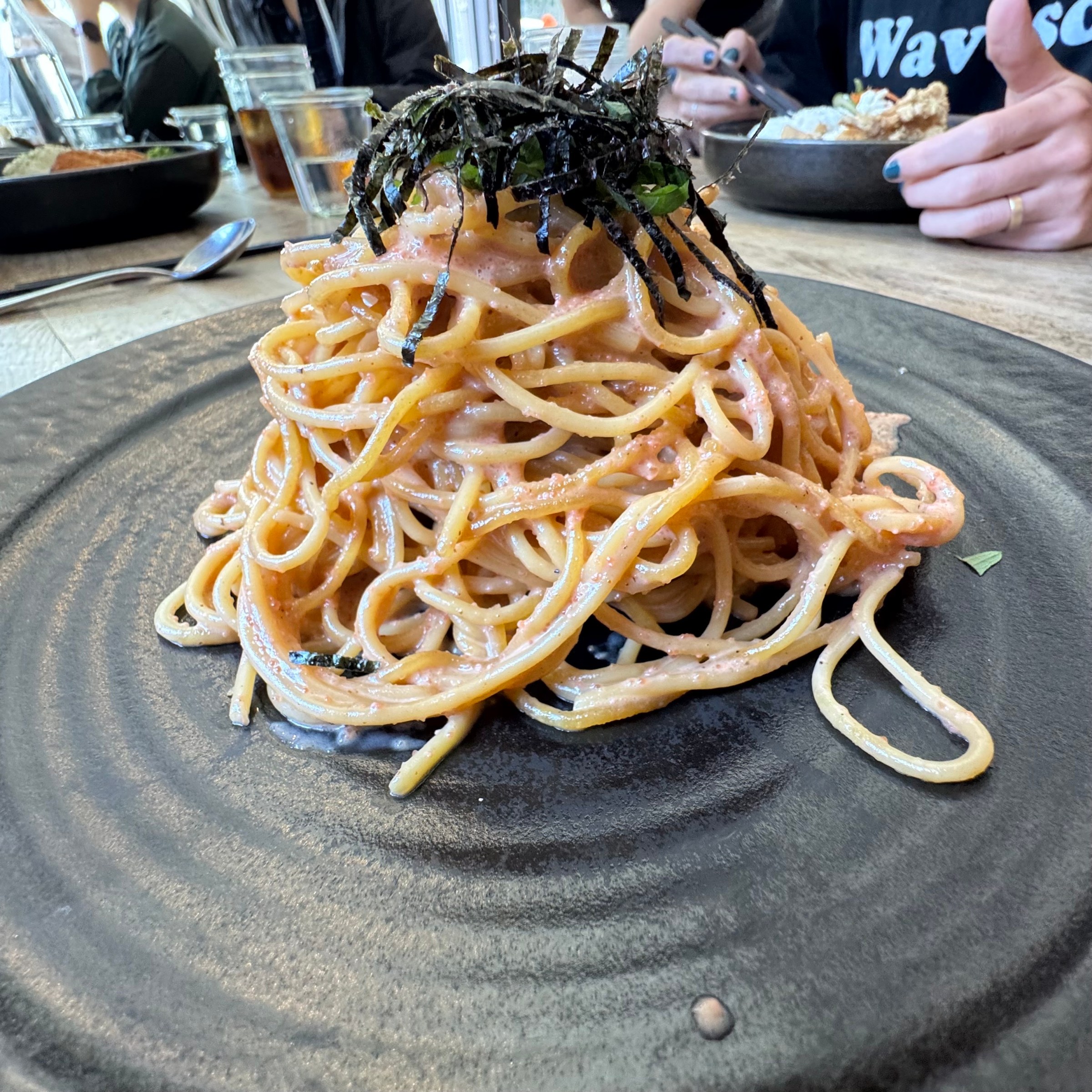 Mentaiko spaghetti on a black plate at Bon, Nene in San Francisco.