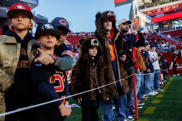 Matt Warren and his 7-year-old son, Roger Warren, wear bear jackets while watching players warm up before the Bears play the 49ers on Sunday, Dec. 28, 2025, at Levi's Stadium in Santa Clara, Calif. (Armando L. Sanchez/Chicago Tribune)