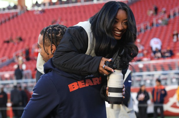 Olympic gymnast Simone Biles is hoisted by her husband, Bears safety Jonathan Owens, during warmups before a game against the 49ers on Sunday, Dec. 28, 2025, at Levi's Stadium in Santa Clara, Calif. (John J. Kim/Chicago Tribune)