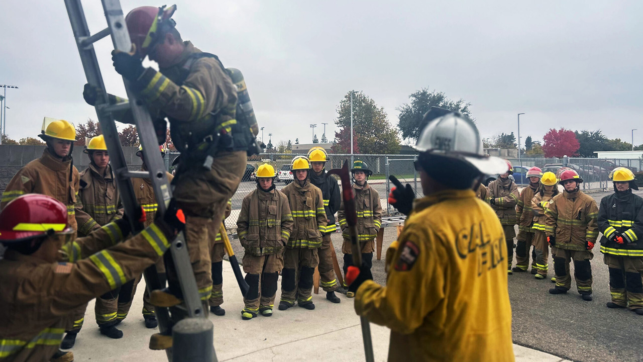 George Mavrikis, the instructor for Clovis Unified School District’s firefighter training program, tells students about the requirement to climb a ladder in the fire academy.
