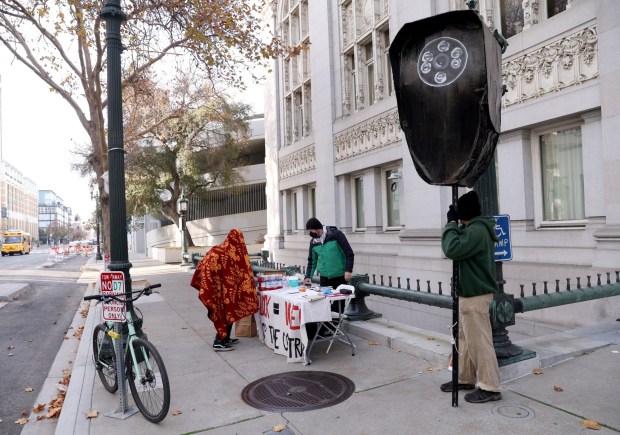 Anti-camera activists set up a table outside during an Oakland City Council meeting at City Hall in Oakland, Calif., on Tuesday, Dec. 16, 2025. The Oakland City Council voted 7-1 to award Flock Safety a new contract to maintain an existing network of 300 cameras in the city. (Jane Tyska/Bay Area News Group)