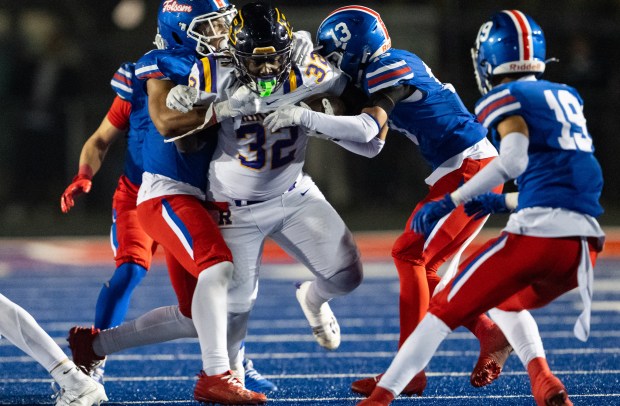 Folsom defenders hold Riordan Crusaders running back Adonyae Brown (32) to a short gain in the second half of the a CIF Northern California Regional Division 1-AA football championship game in Folsom on Friday, Dec. 5, 2025. (Nathaniel Levine/The Sacramento Bee)