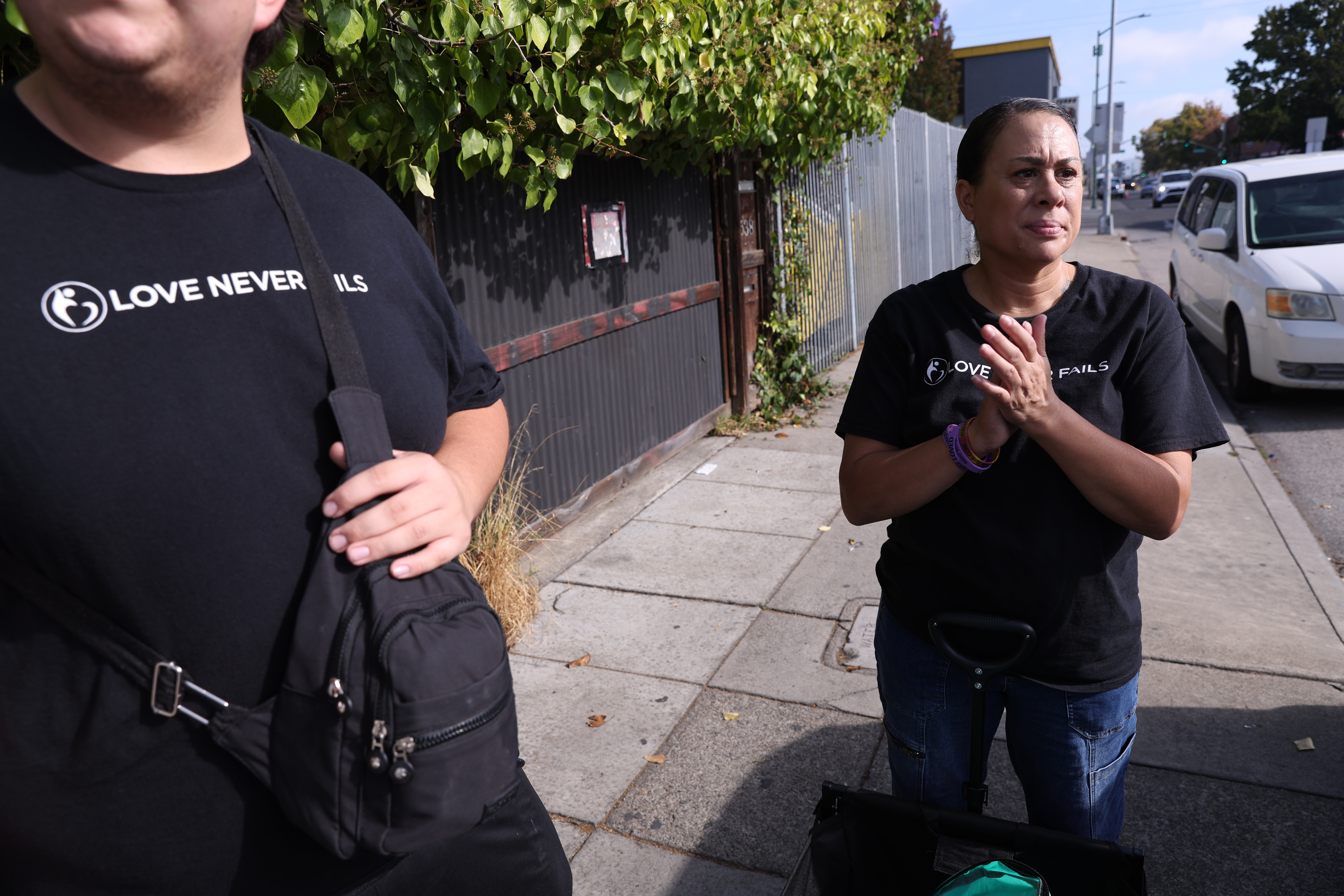 Love Never Fails staff member Leanette Guillory-Higuera prays with others...