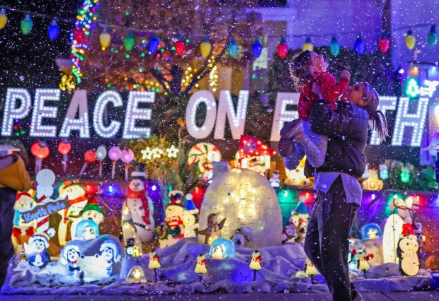 Britt Allen, of Livermore, plays with her son, Wyatt, 3, as snow from a snow-making machine falls as part of the Christmas display at Alex Dourov's Knottingham Circle extravaganza in Livermore, Calif., on Wednesday, Dec. 11, 2024. (Ray Chavez/Bay Area News Group)