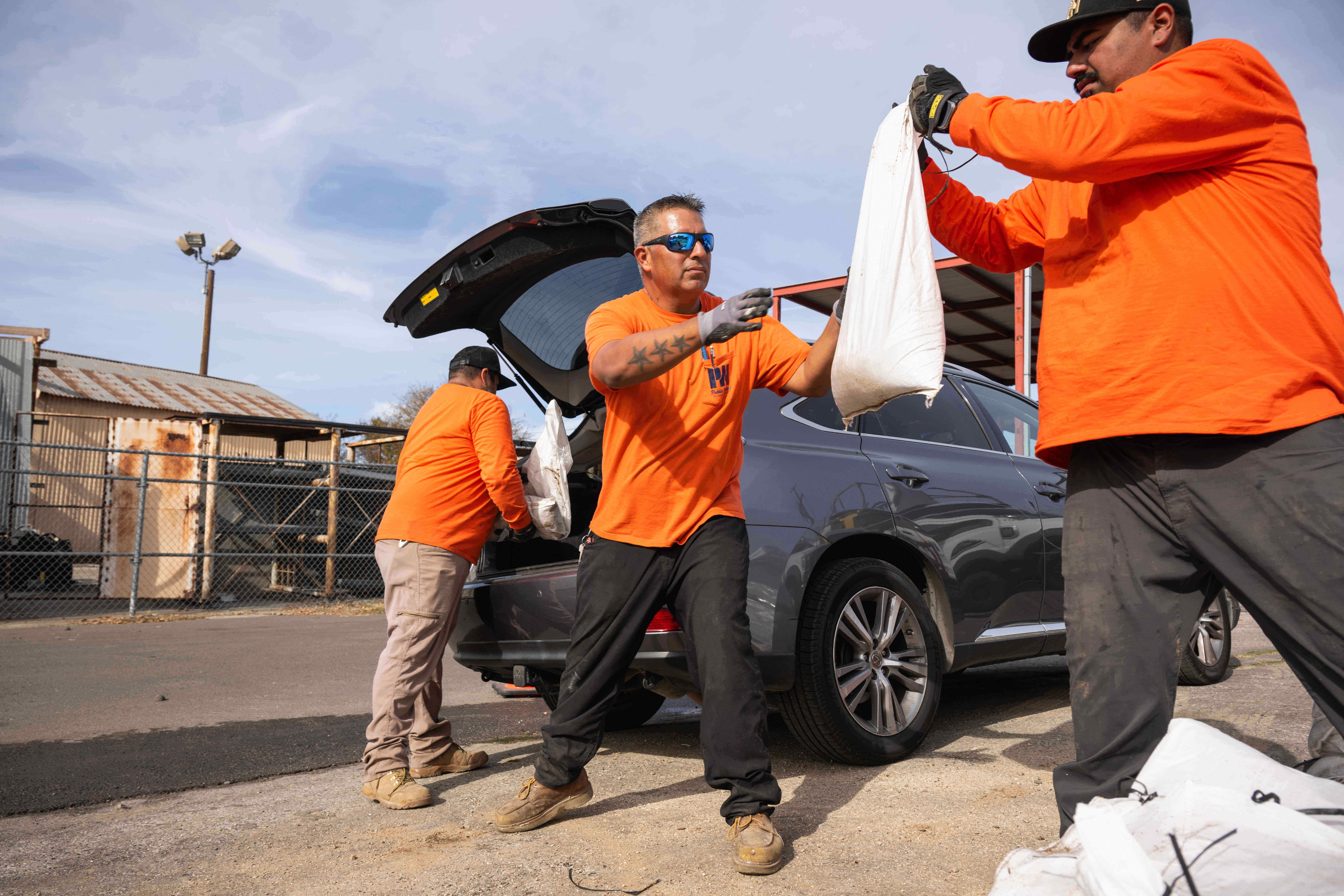 Los Angeles County Public Works crew loads sandbags for residents...