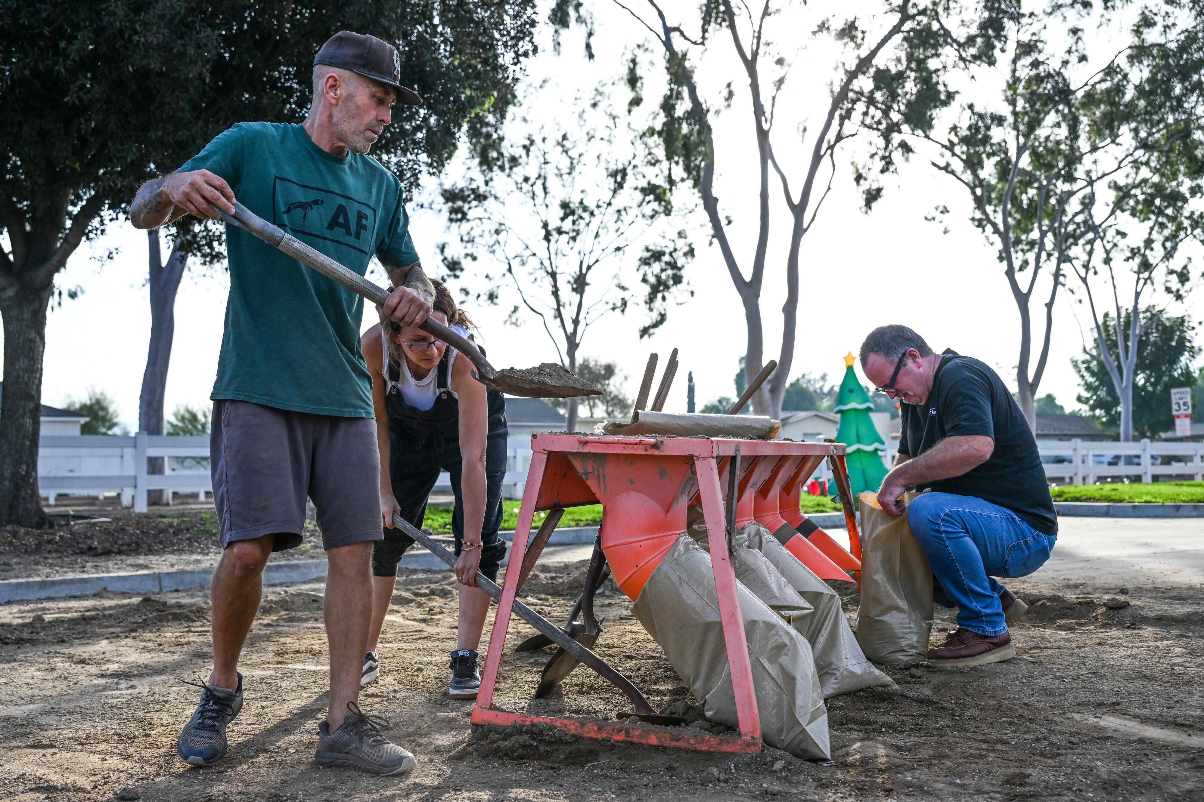 Norco resident Robert Gray and Terry McCauley fill sandbags at...
