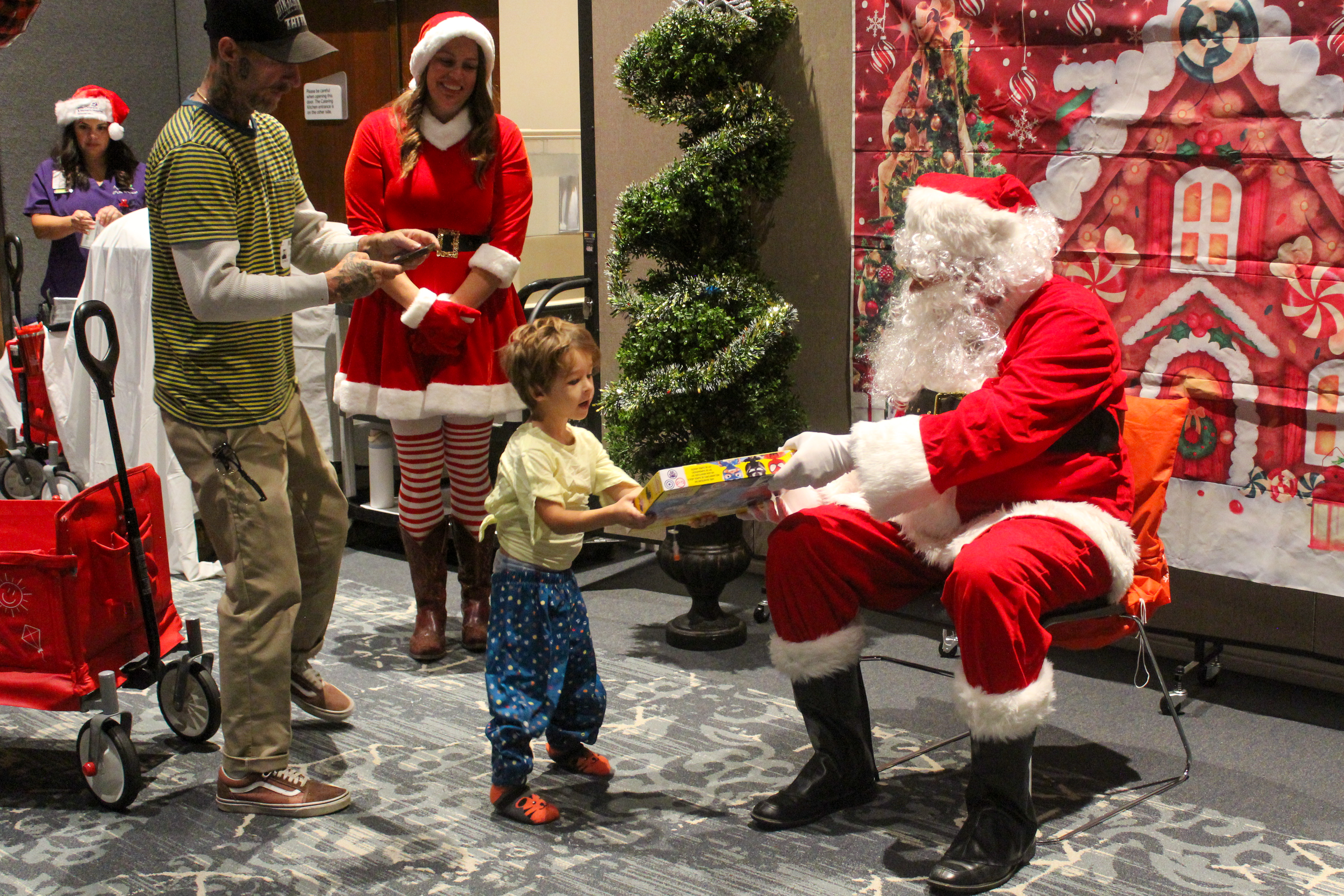 Santa Claus handed out gifts and posed for pictures with...