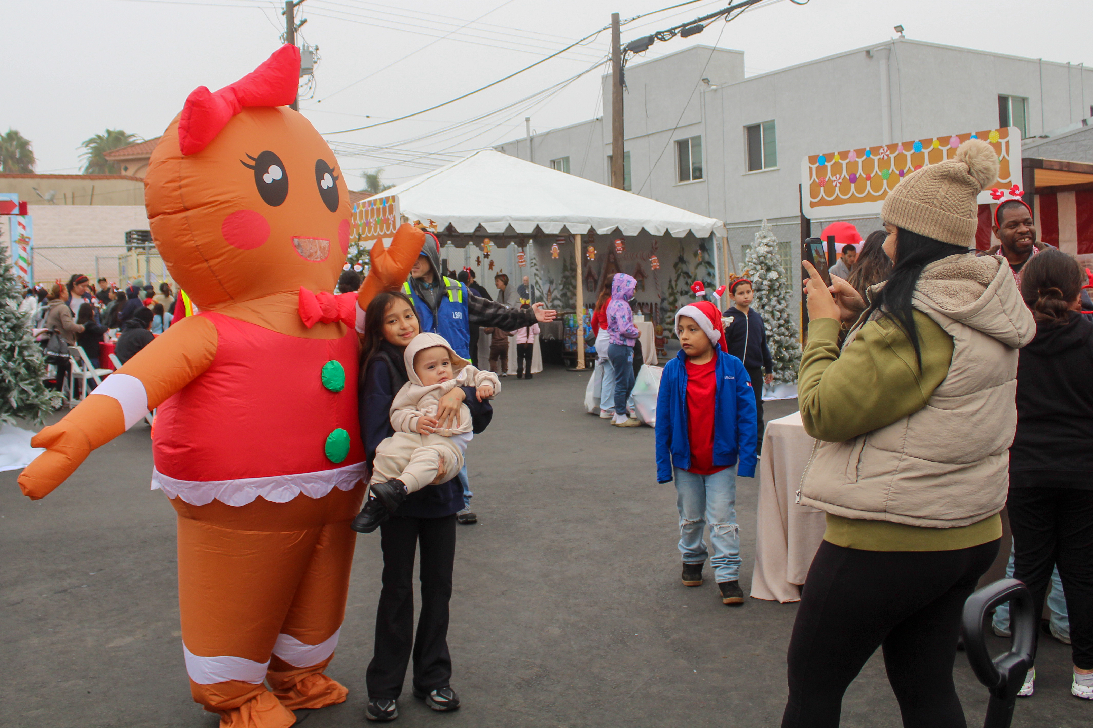 A family taking pictures with an inflatable gingerbread person at...