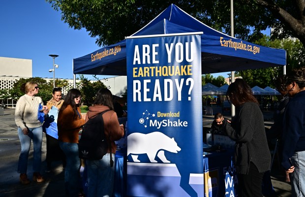 People gather at a booth offering information on earthquake readiness as the Earthquake Simulator from the California Governor's Office of Emergency Services makes a stop on the campus of California State University Fullerton, in Fullerton, California earlier this year. (Photo by Frederic J. Brown/AFP via Getty Images)