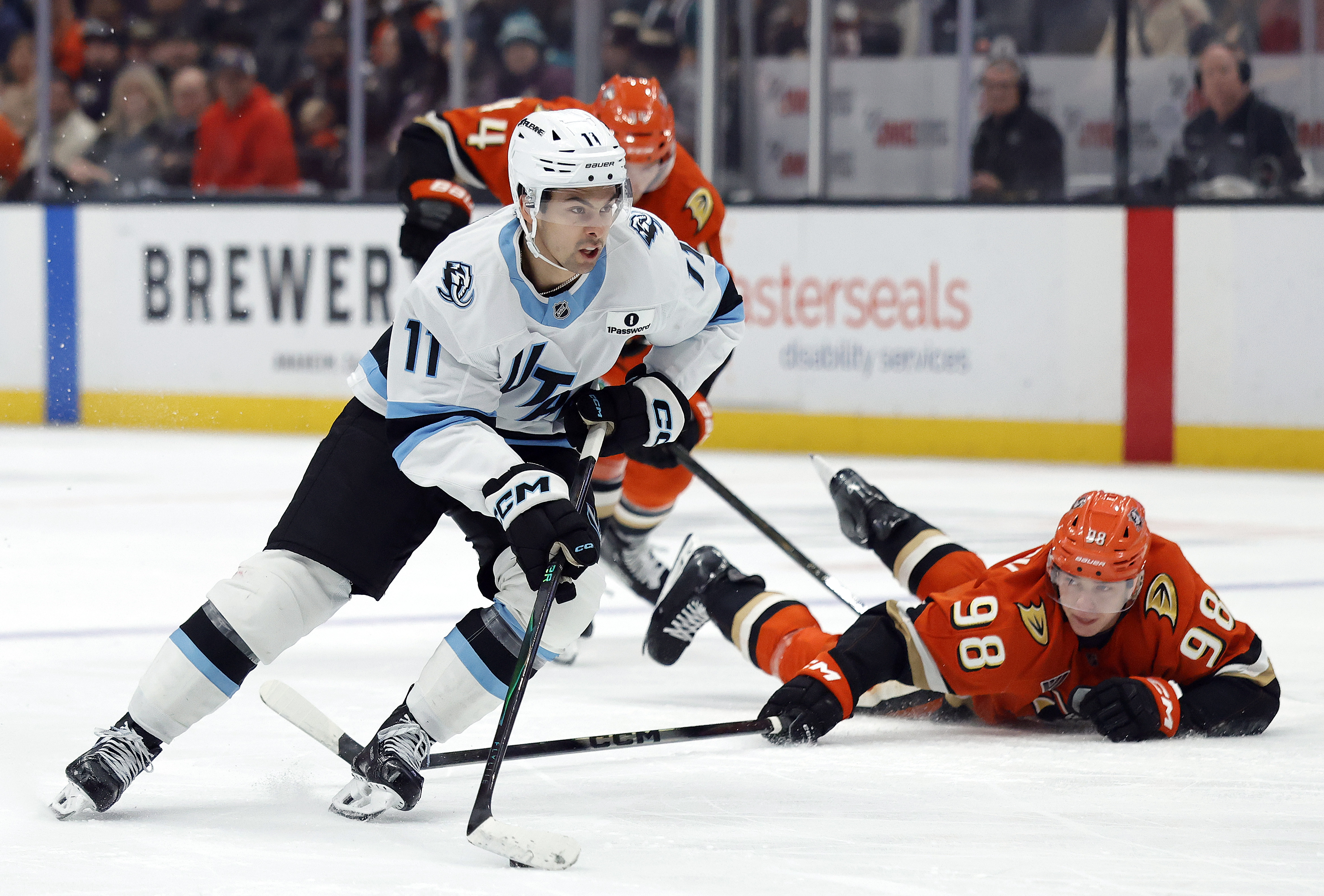 The Utah Mammoth’s Dylan Guenther skates the puck past the...