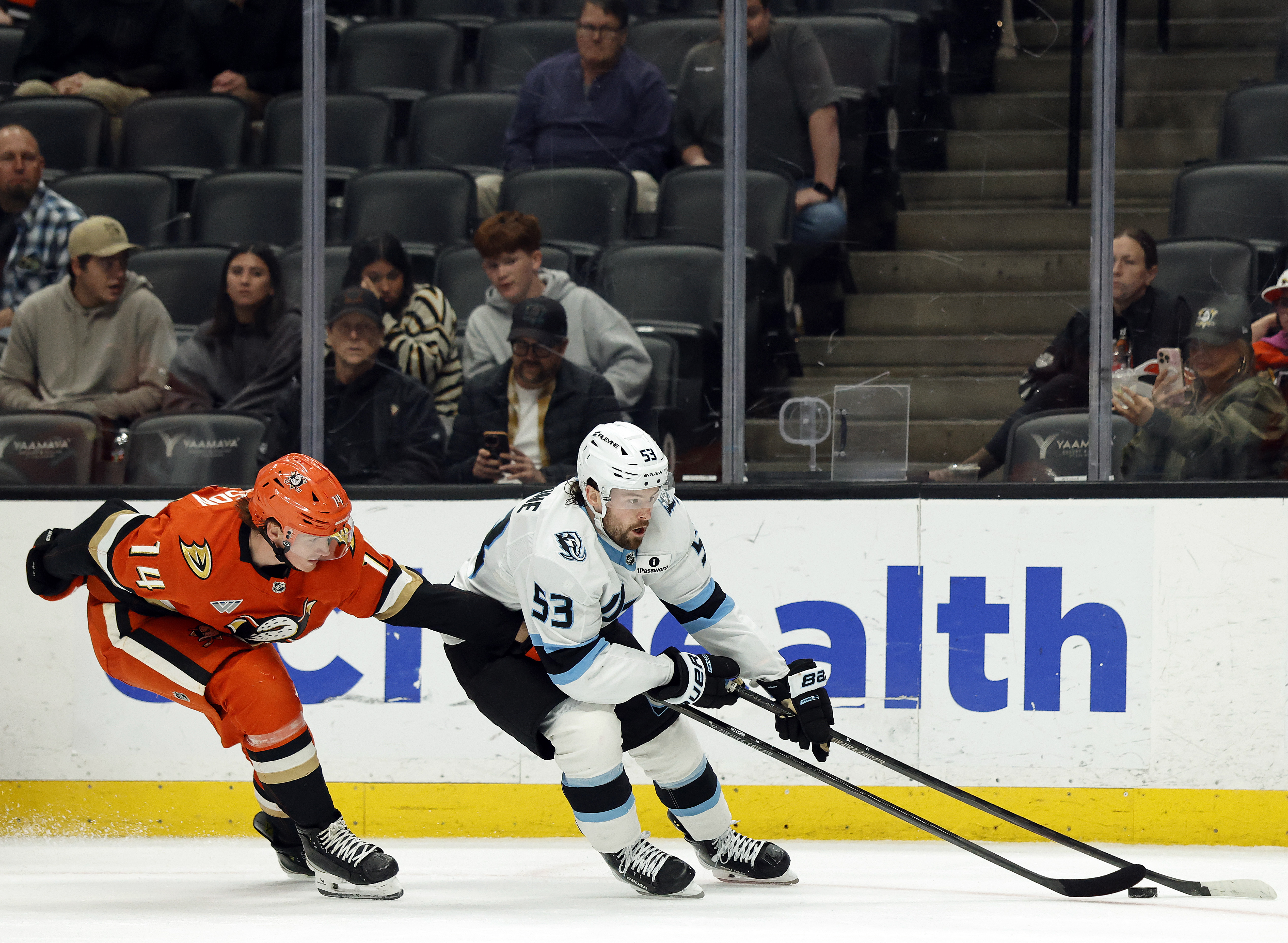 The Utah Mammoth’s Michael Carcone, right, skates the puck as...