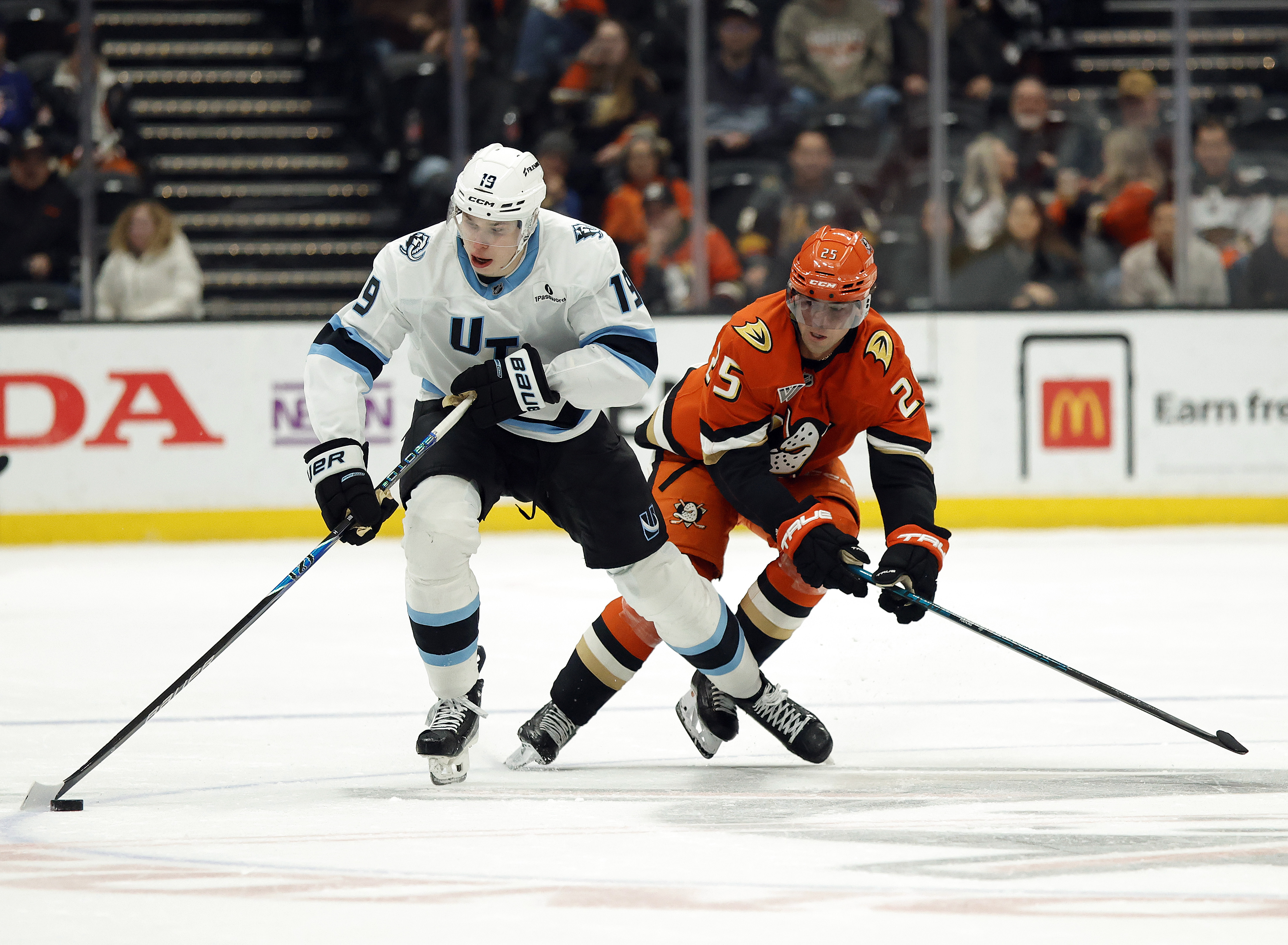 The Utah Mammoth’s Daniil But, left, skates the puck as...