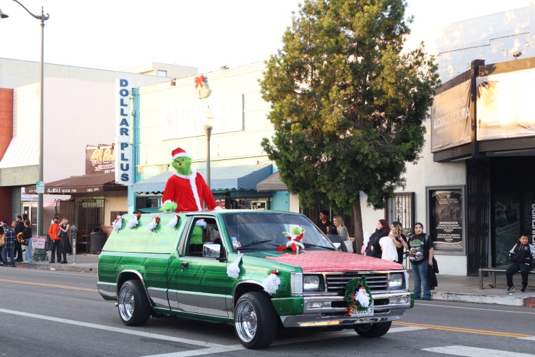 The Grinch makes his way through the parade in a lowrider.