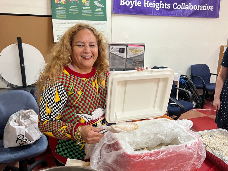 Angela Gutierrez shows off the tamales she helped make during the tamalada  for a holiday convivio at Proyecto Pastoral