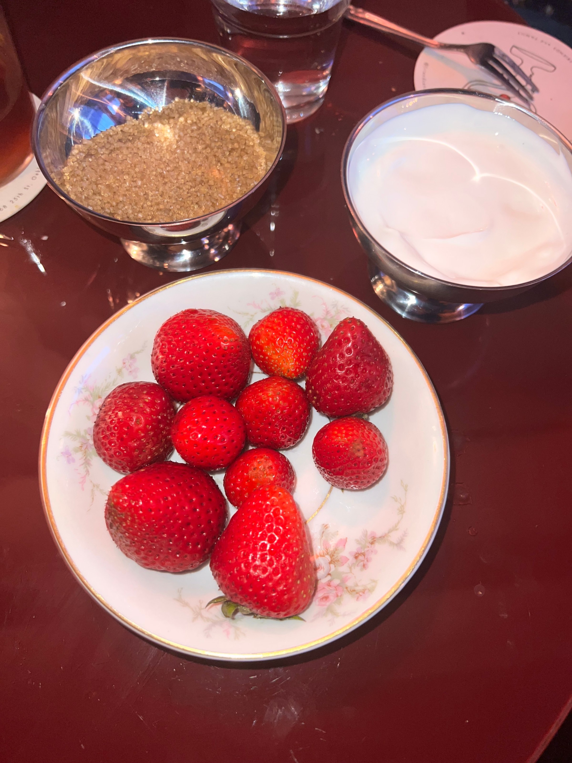 A dish of strawberries with sugar and cream.