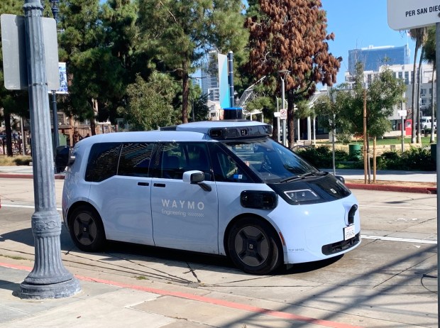 A Waymo Zeekr RT autonomous van, with a human driver, on Front Street in downtown San Diego in November 2025. (Dan Beucke/The San Diego Union-Tribune)