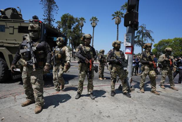 Federal agents stage at MacArthur Park, July 7, 2025, in Los Angeles. (AP Photo/Damian Dovarganes)