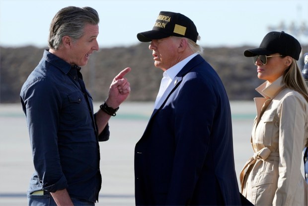 President Donald Trump and first lady Melania Trump listen to California Gov. Gavin Newsom after arriving on Air Force One at Los Angeles International Airport in Los Angeles, Friday, Jan. 24, 2025. (AP Photo/Mark Schiefelbein)