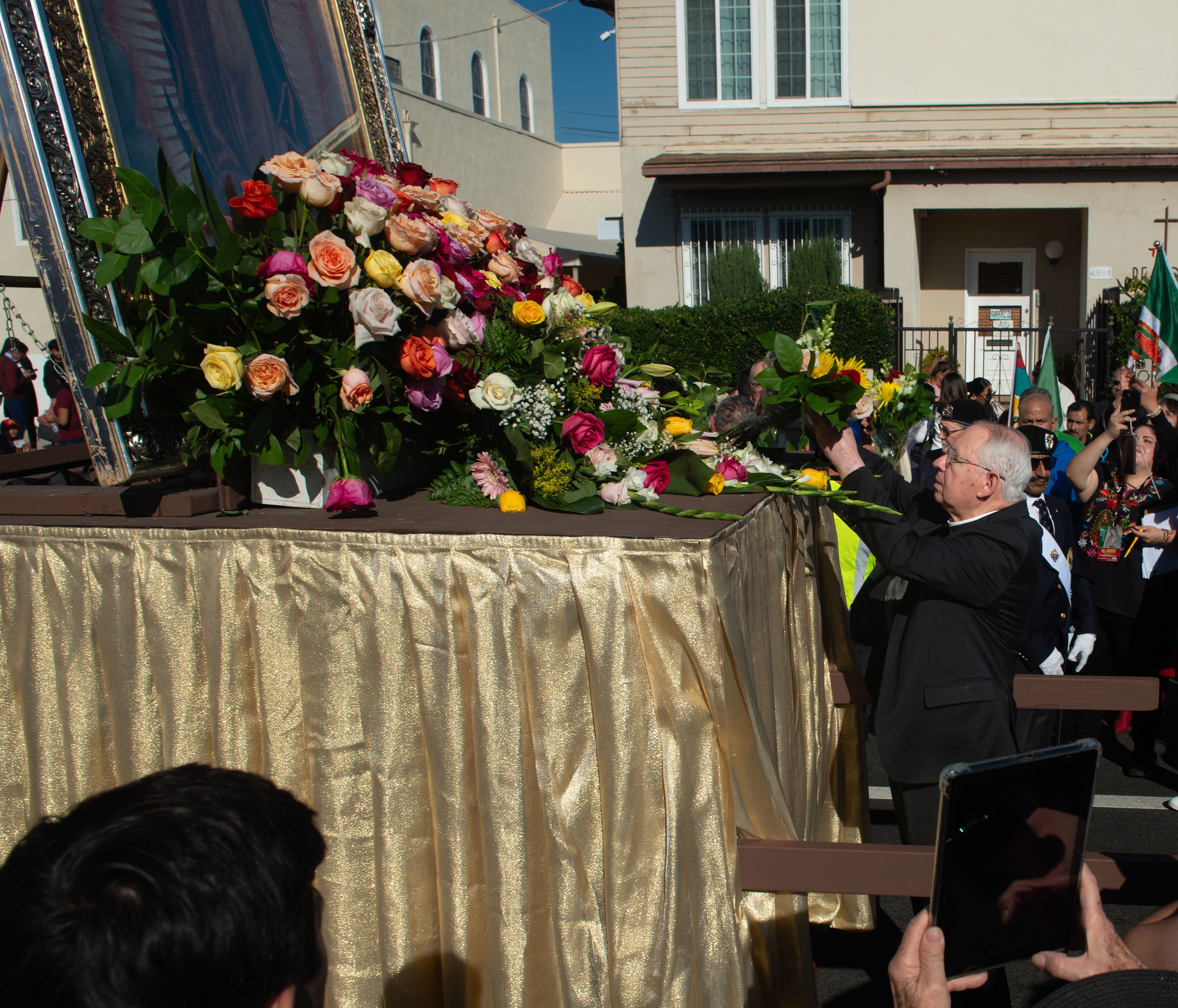 Archbishop Jose Gomes places flowers at the base of one...