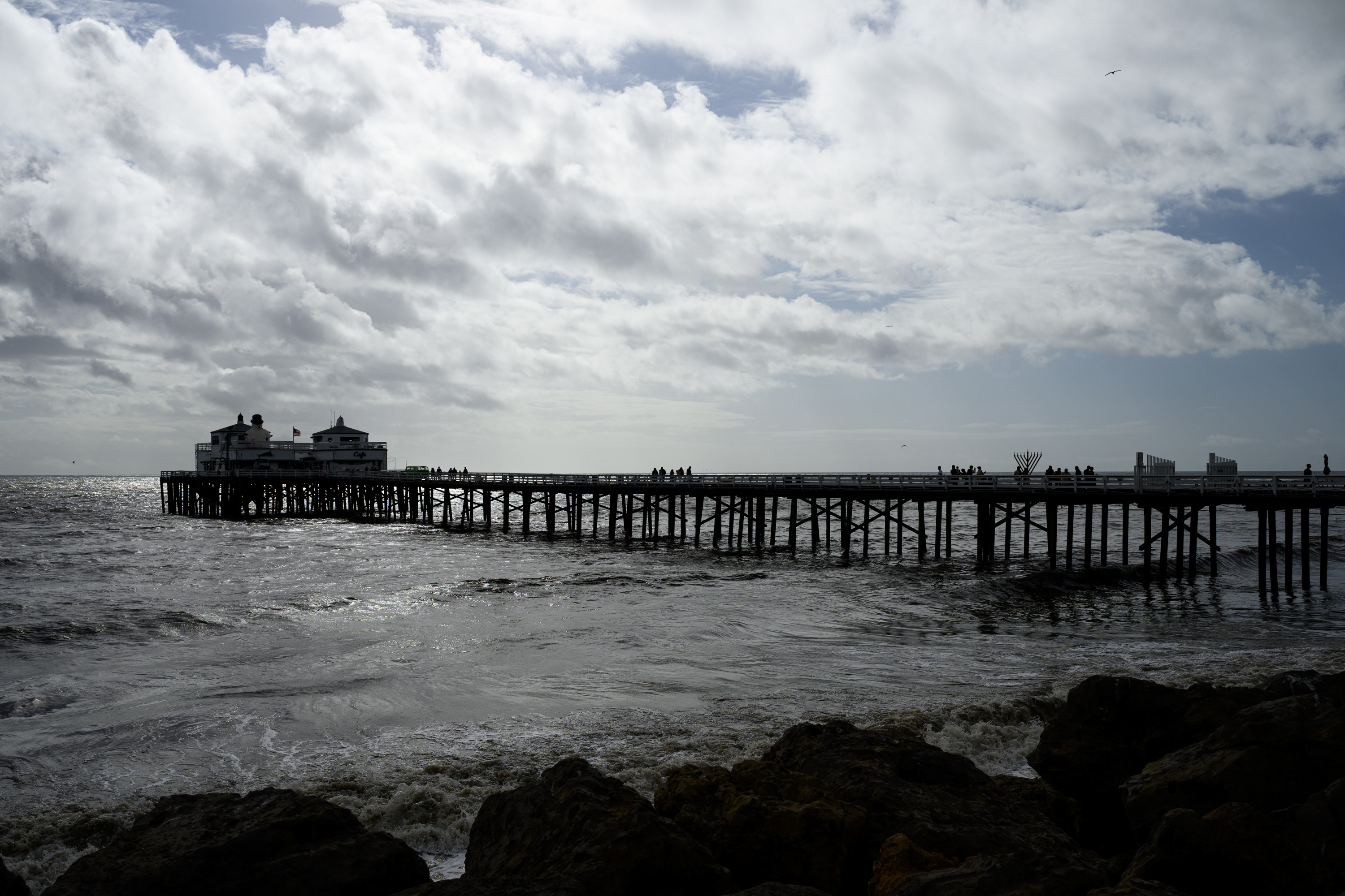 People walk along the Malibu Pier in the morning on...