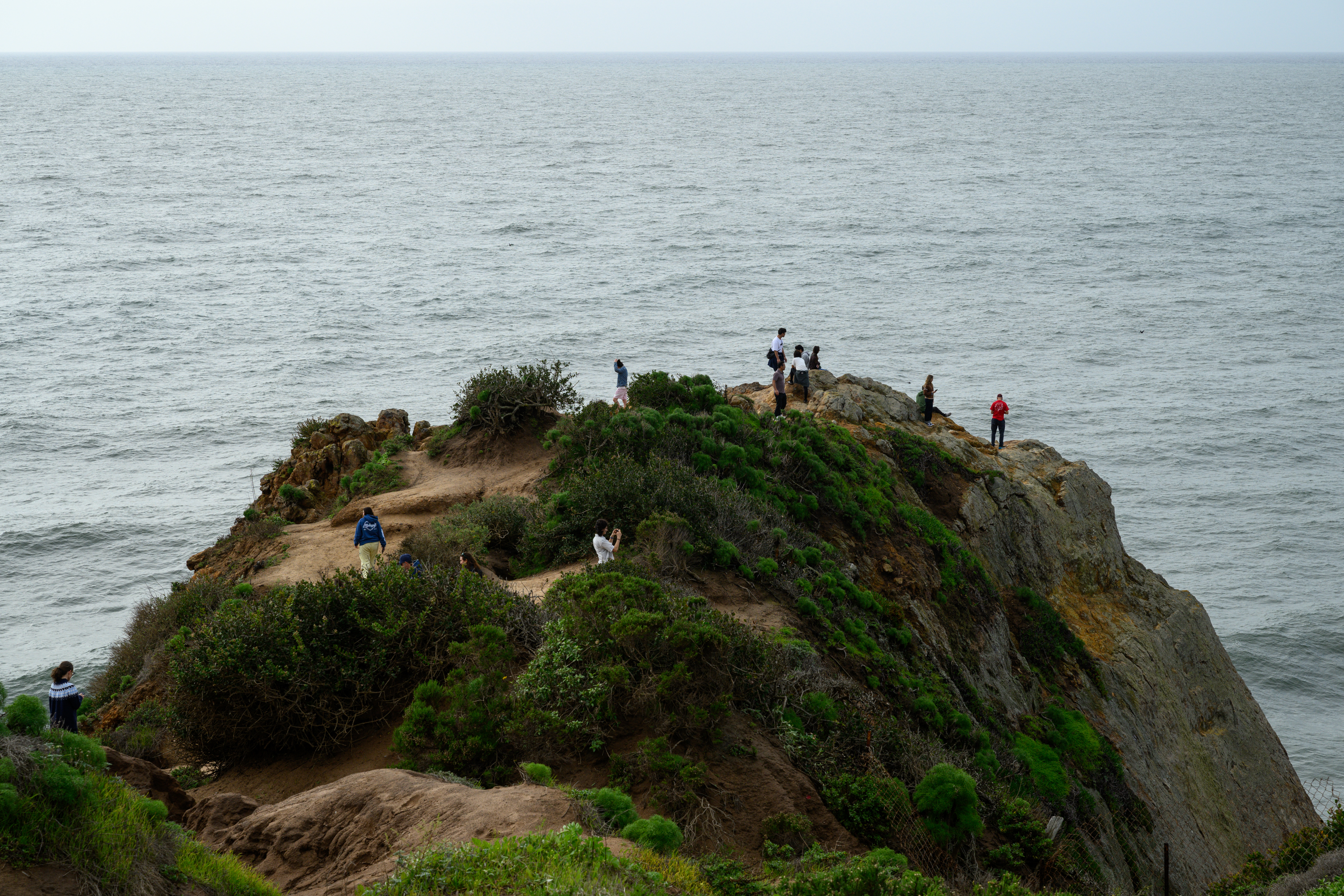People hike Point Dume in Malibu before the storm on...