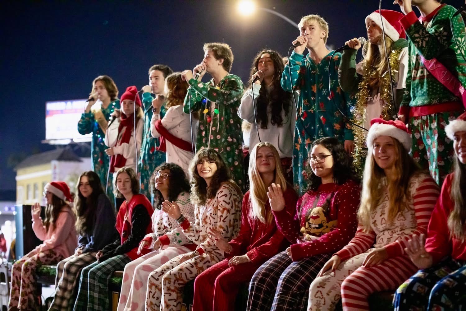 Pajama-wearing students from Millikan High School sing as they ride...