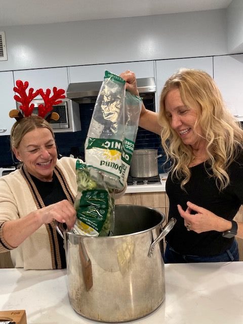 Volunteers Jennifer Davis (right) and her aunt Ginger Blakkolb cook...
