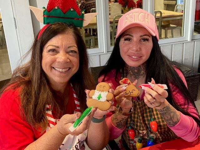 Volunteers Lori Daunis (left) and daughter Tatum Mosier decorate cookies...