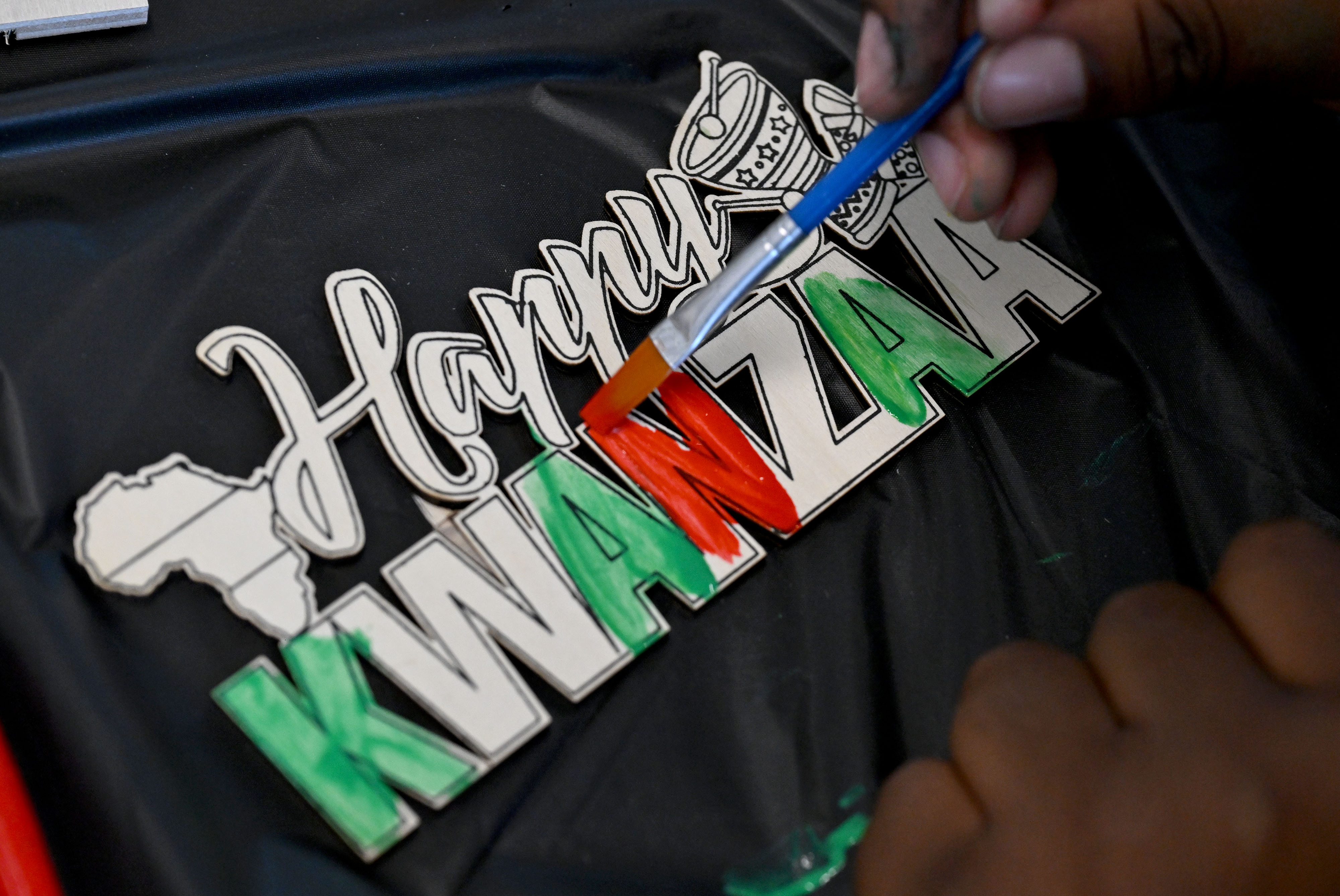 A young boy paints his project during an arts and...