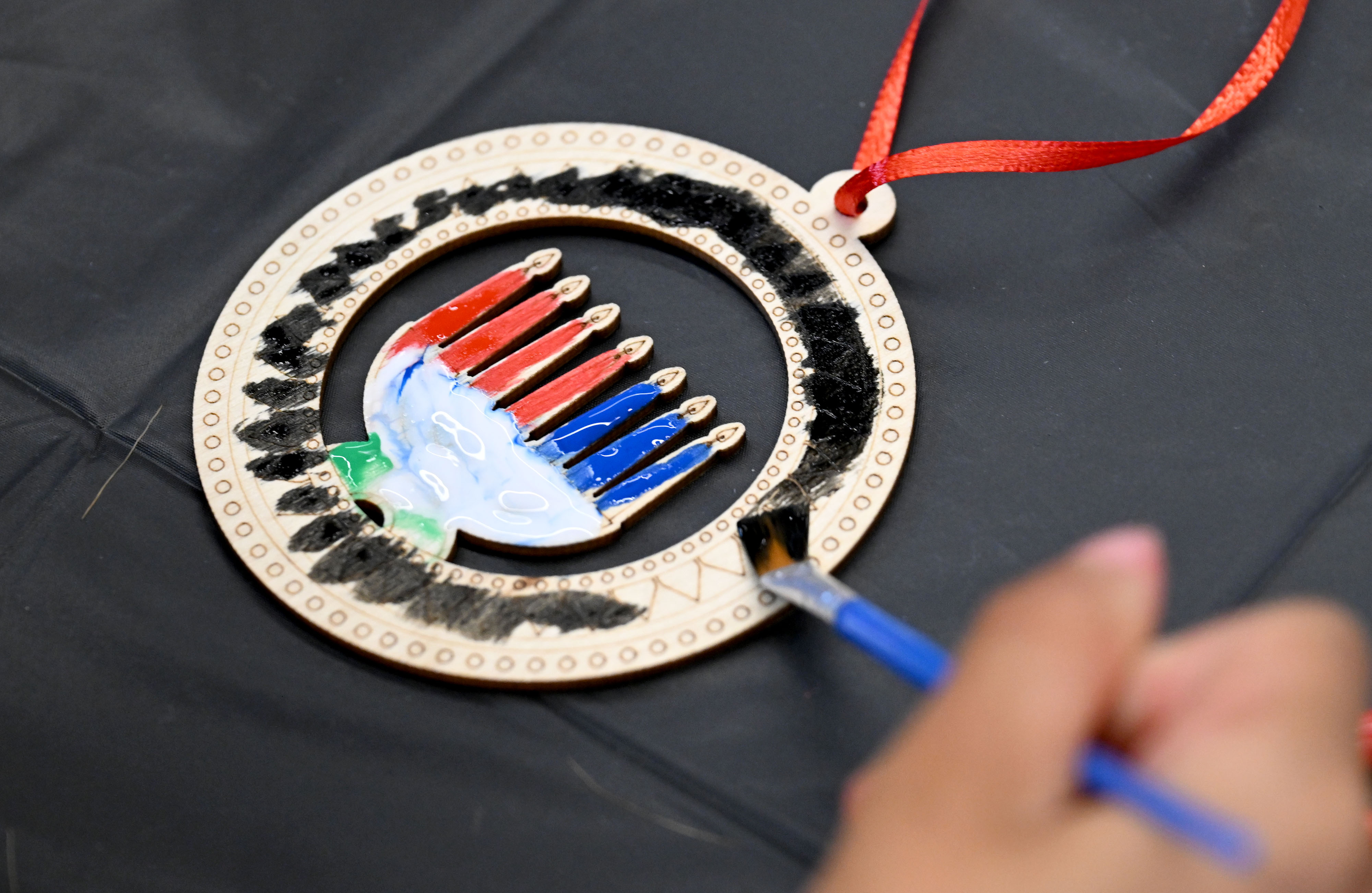 Aiyla Walker, 6, paints her project during an arts and...