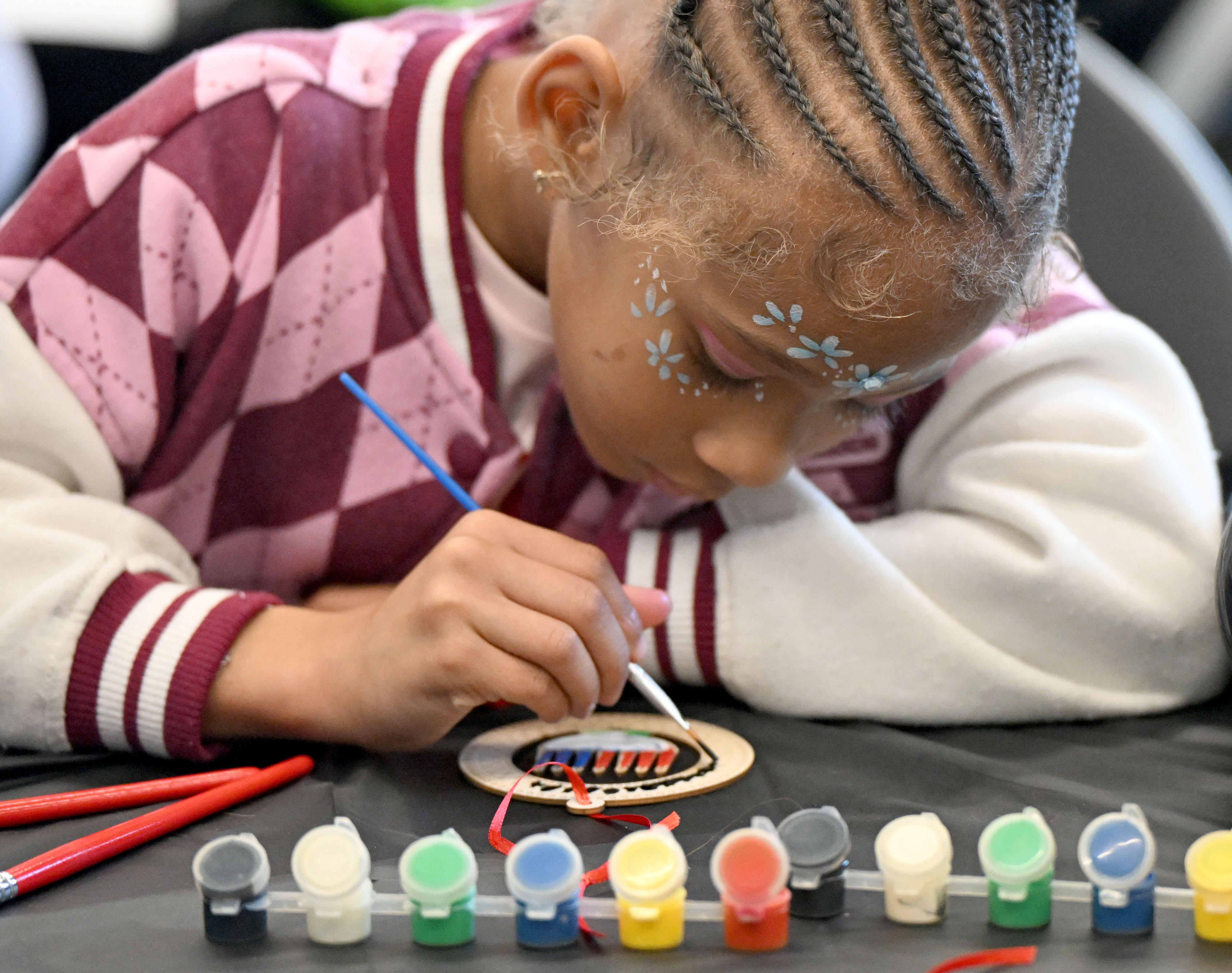 Aiyla Walker, 6, paints her project during an arts and...