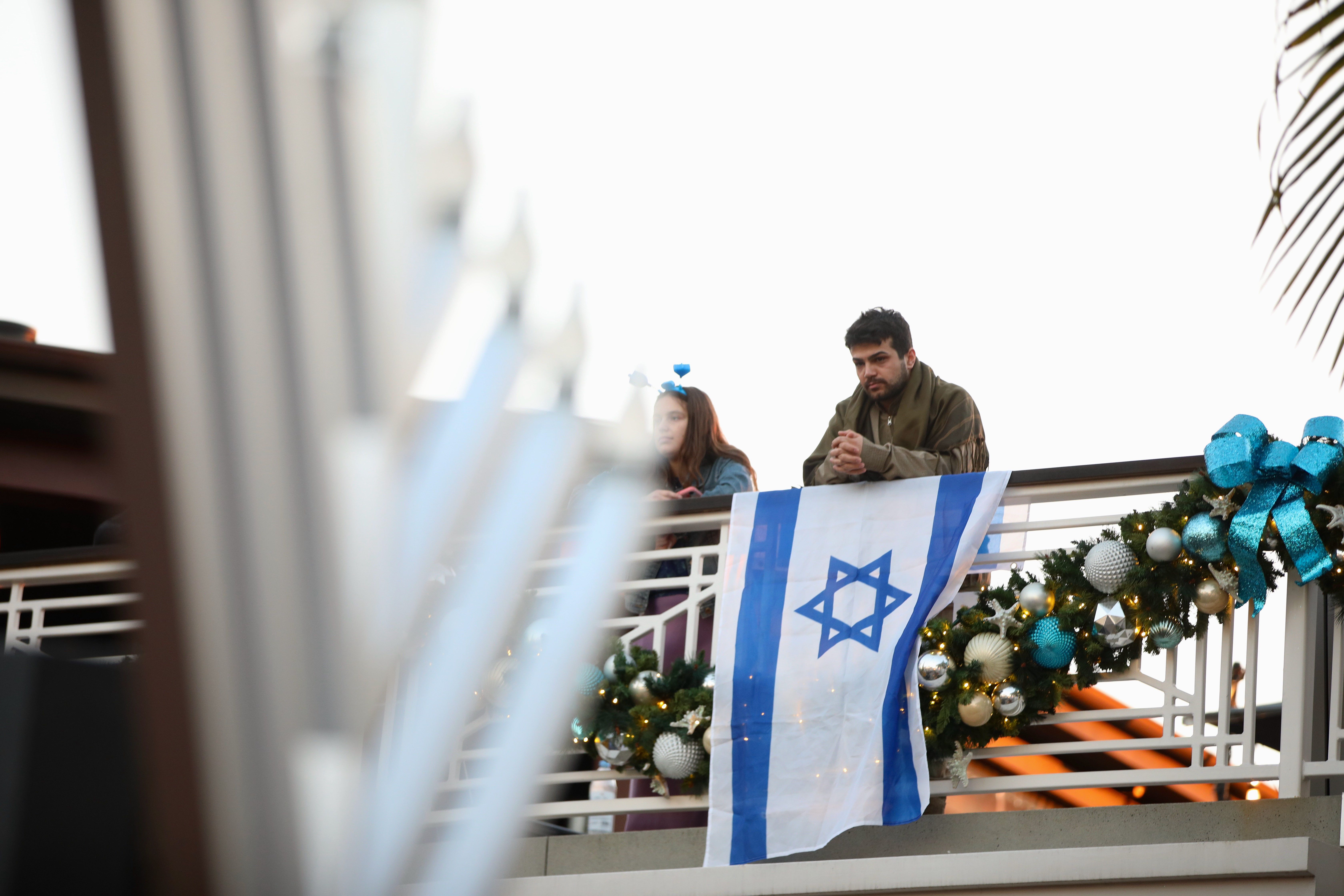 A man with the flag of Israel attends a Hanukkah...
