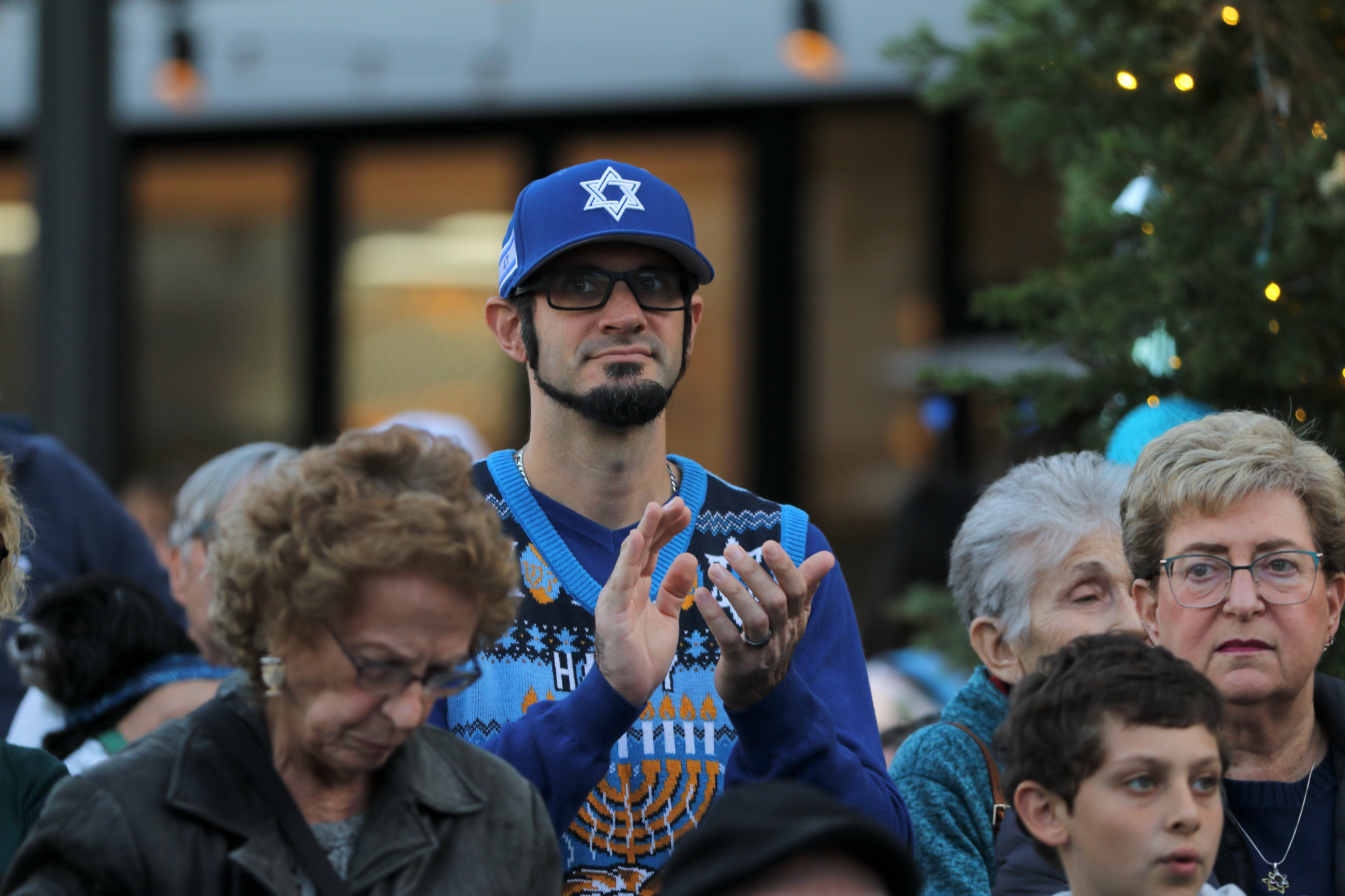 Celebrants attend a Hanukkah menorah lighting event on Sunday, Dec....