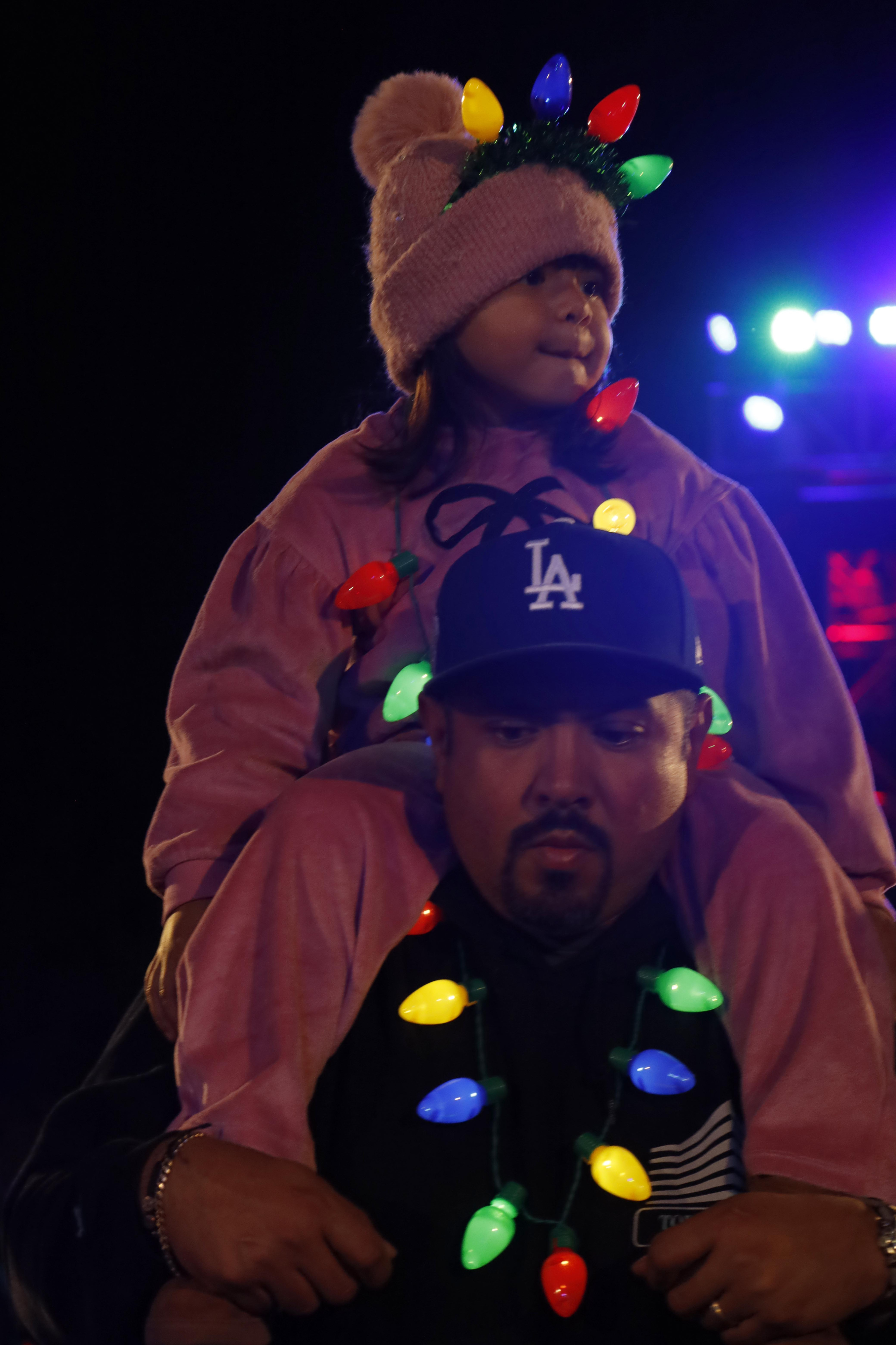 A toddler rides on the shoulders of an adult ,...