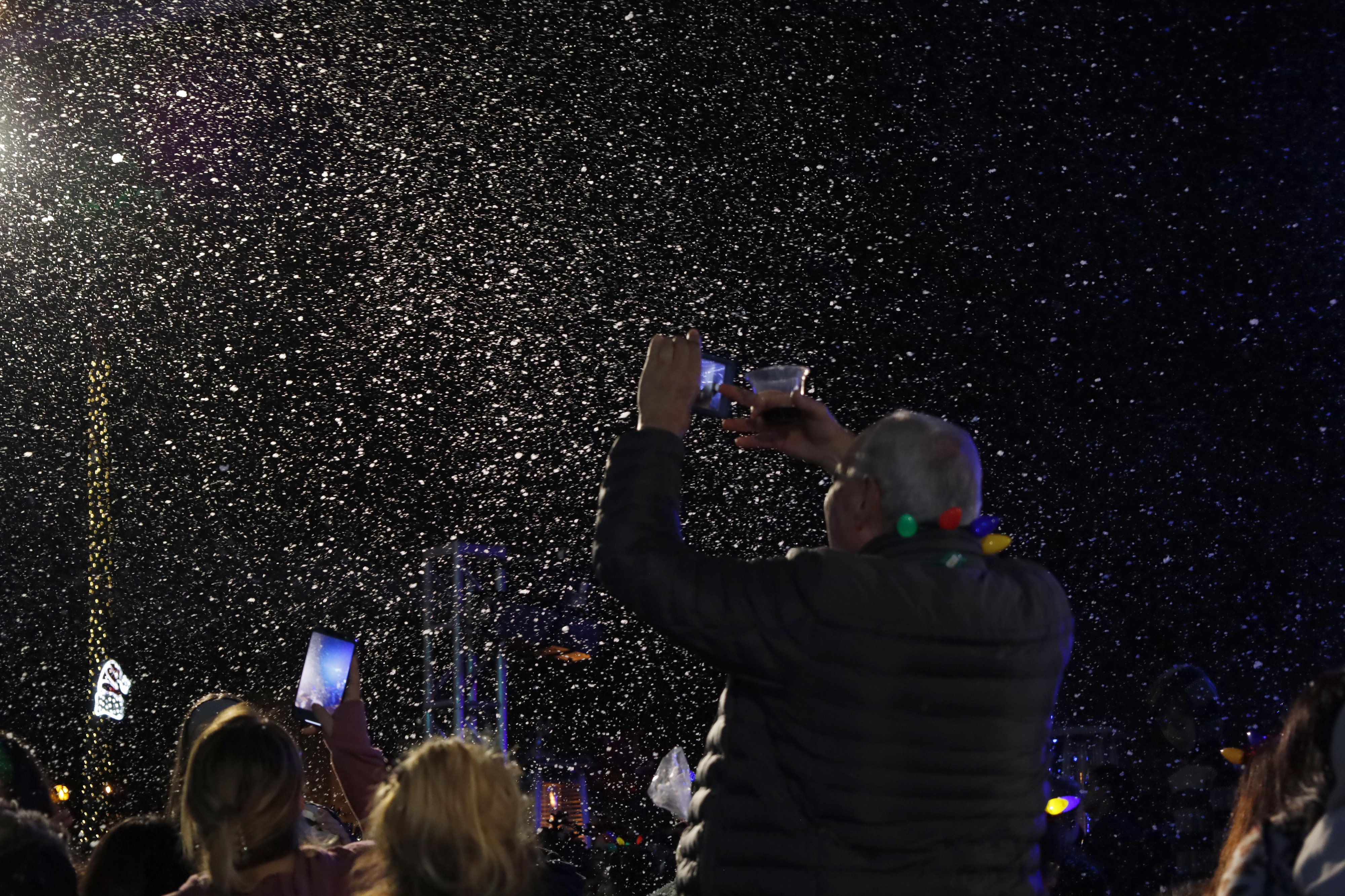 A man stands in the Long Beach crowd taking pictures...