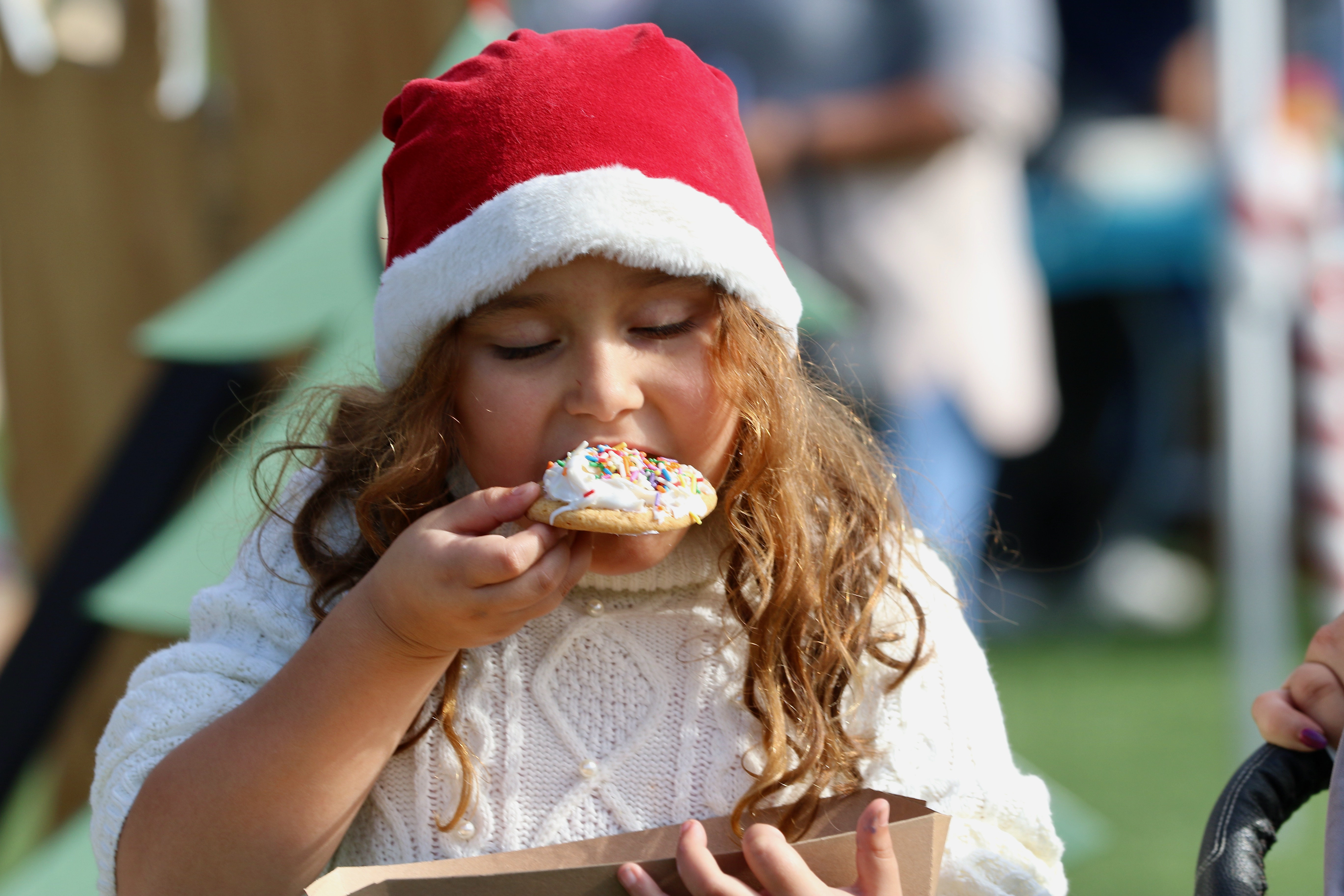 Penny Banks, 6, bites into a holiday cookie at Winter...