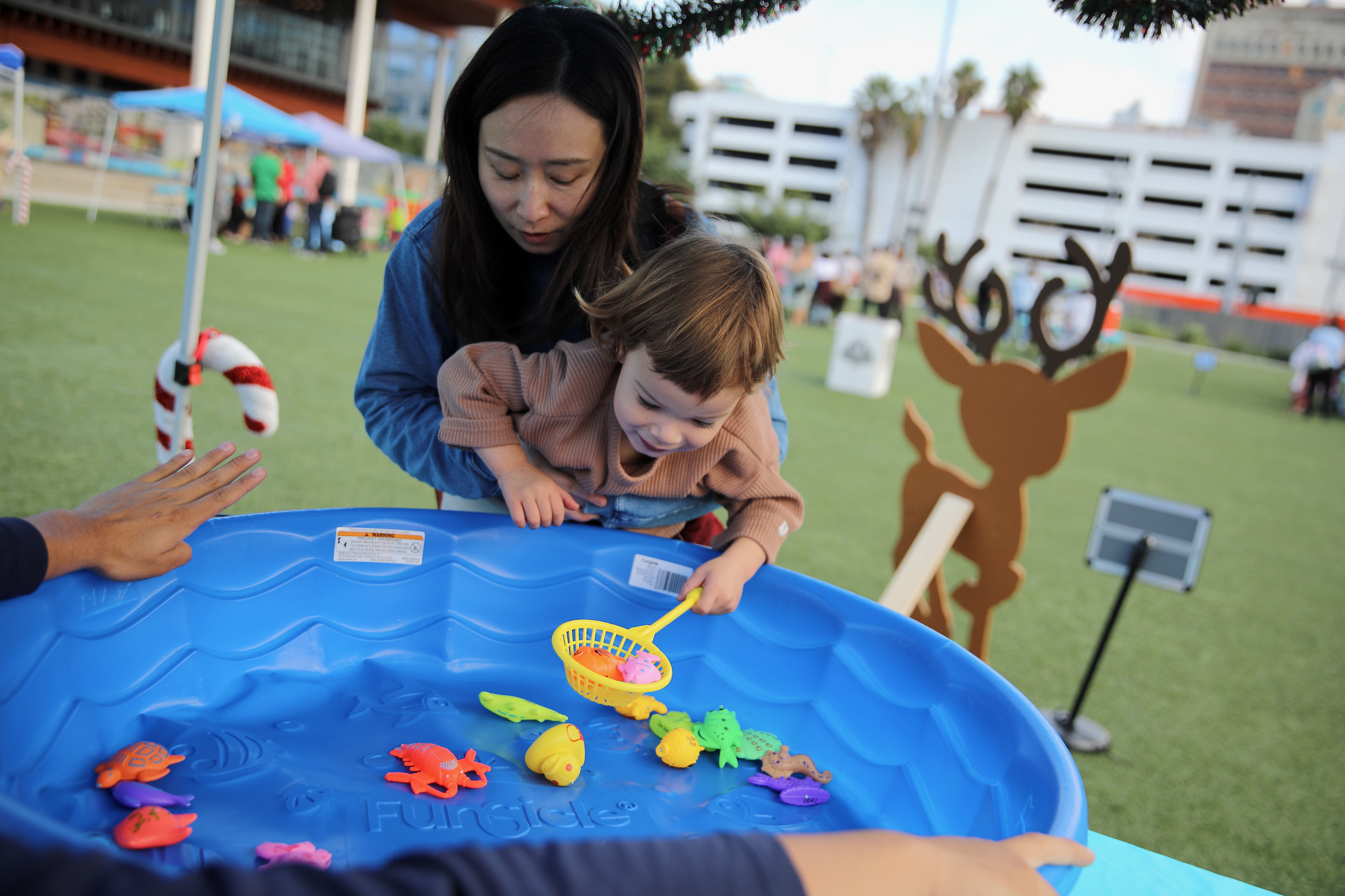 Chen Jacobson of Long Beach helps her son Zane, 3,...