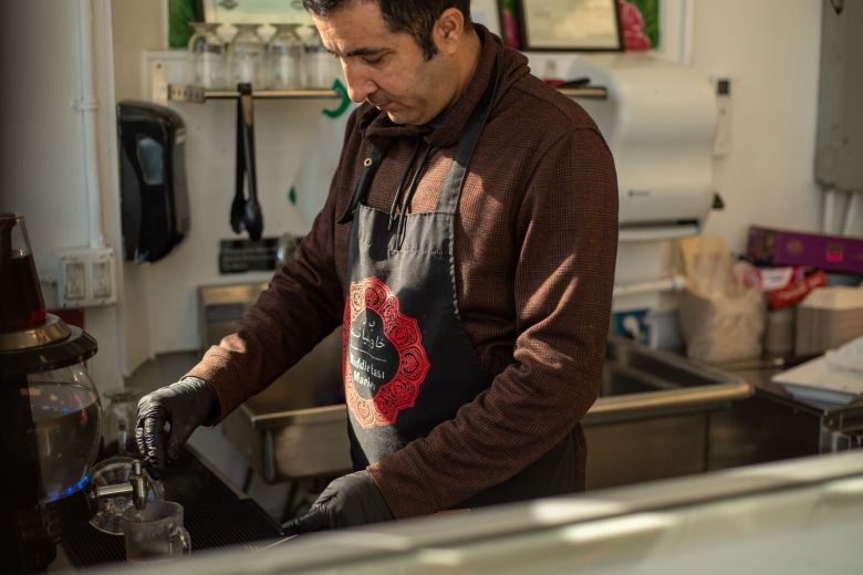 A man makes tea in a Middle Eastern store.