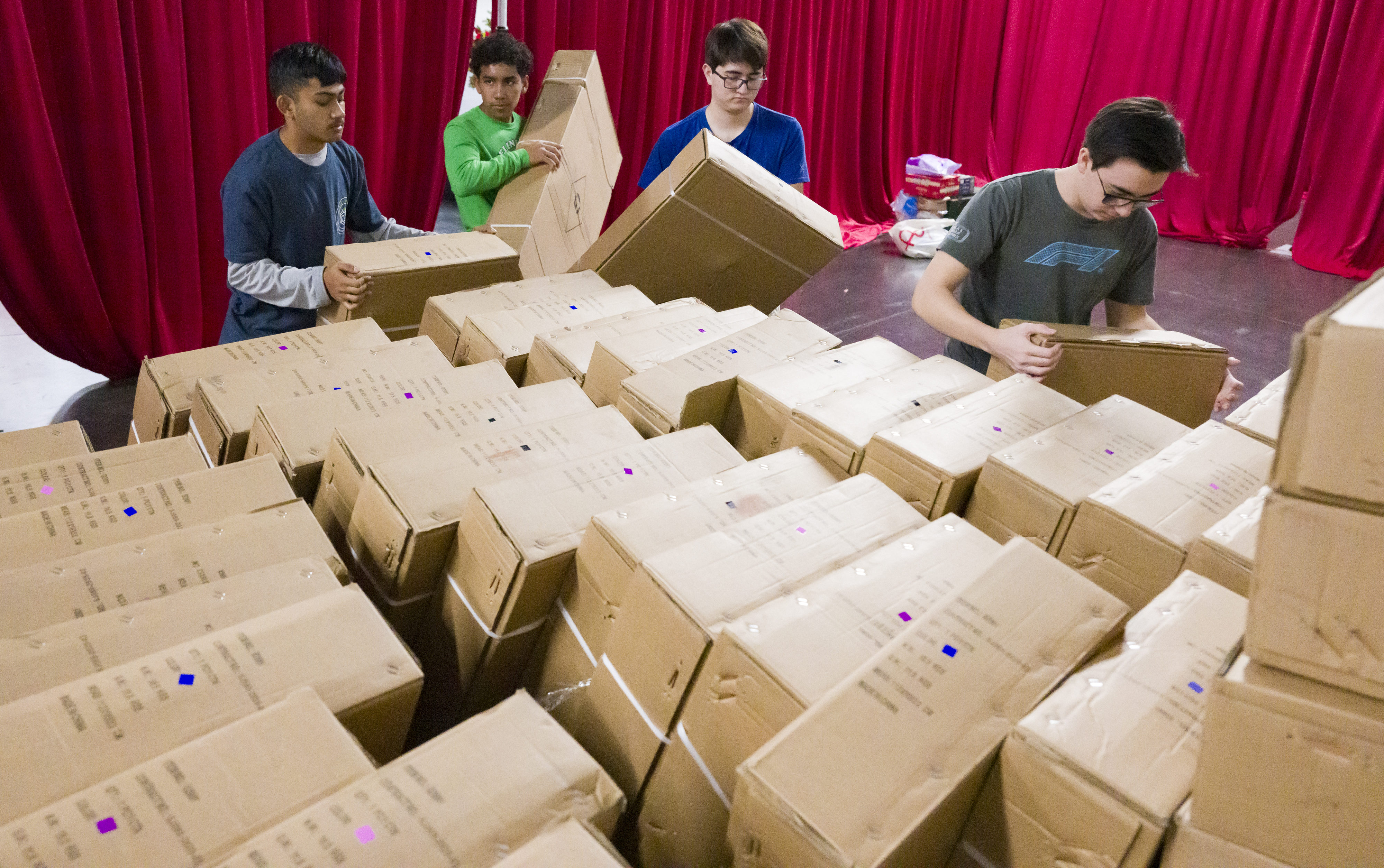 Volunteers stack boxes full of toys as they prepare for...