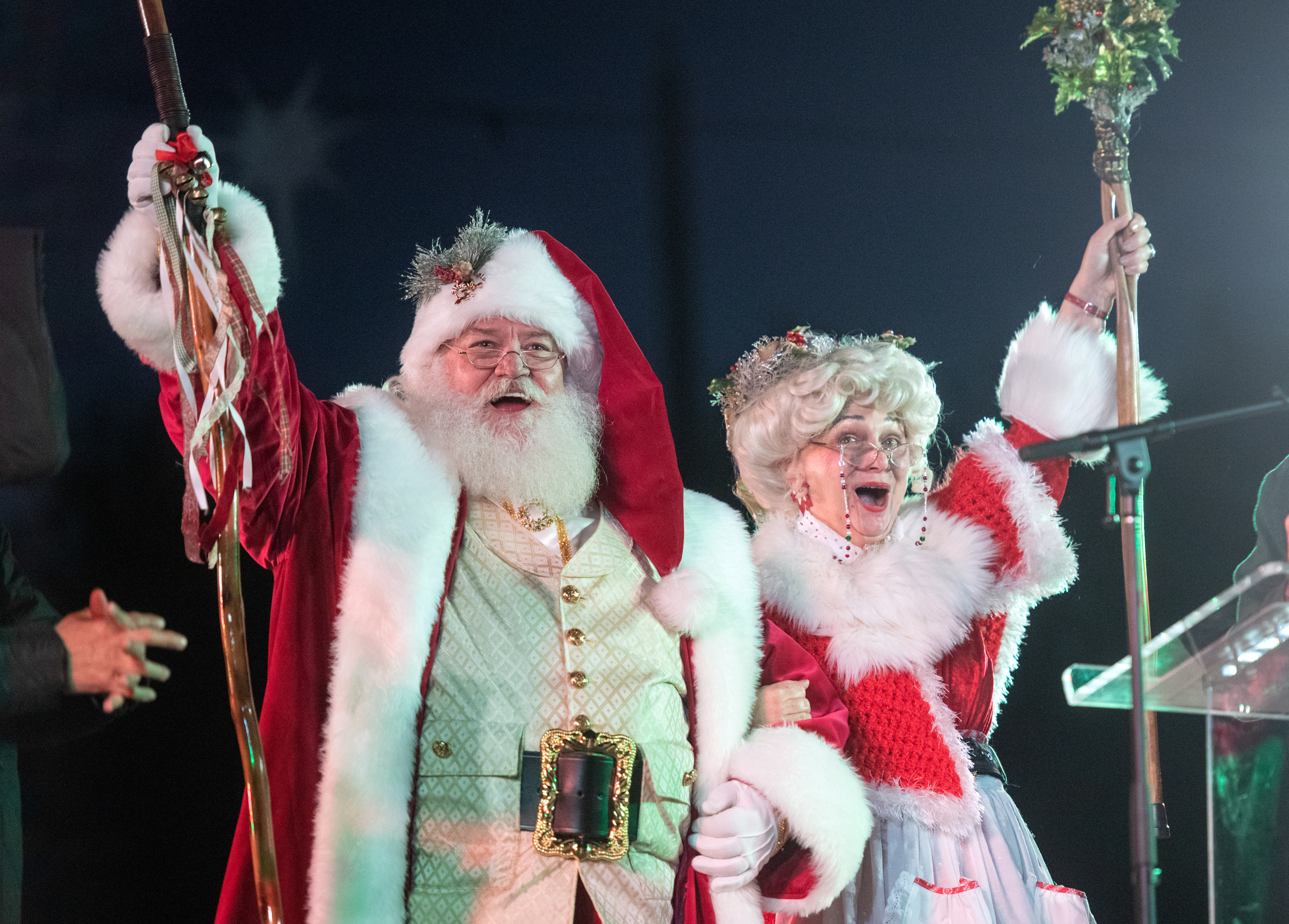 Santa and Mrs. Claus arrive on stage to help light...