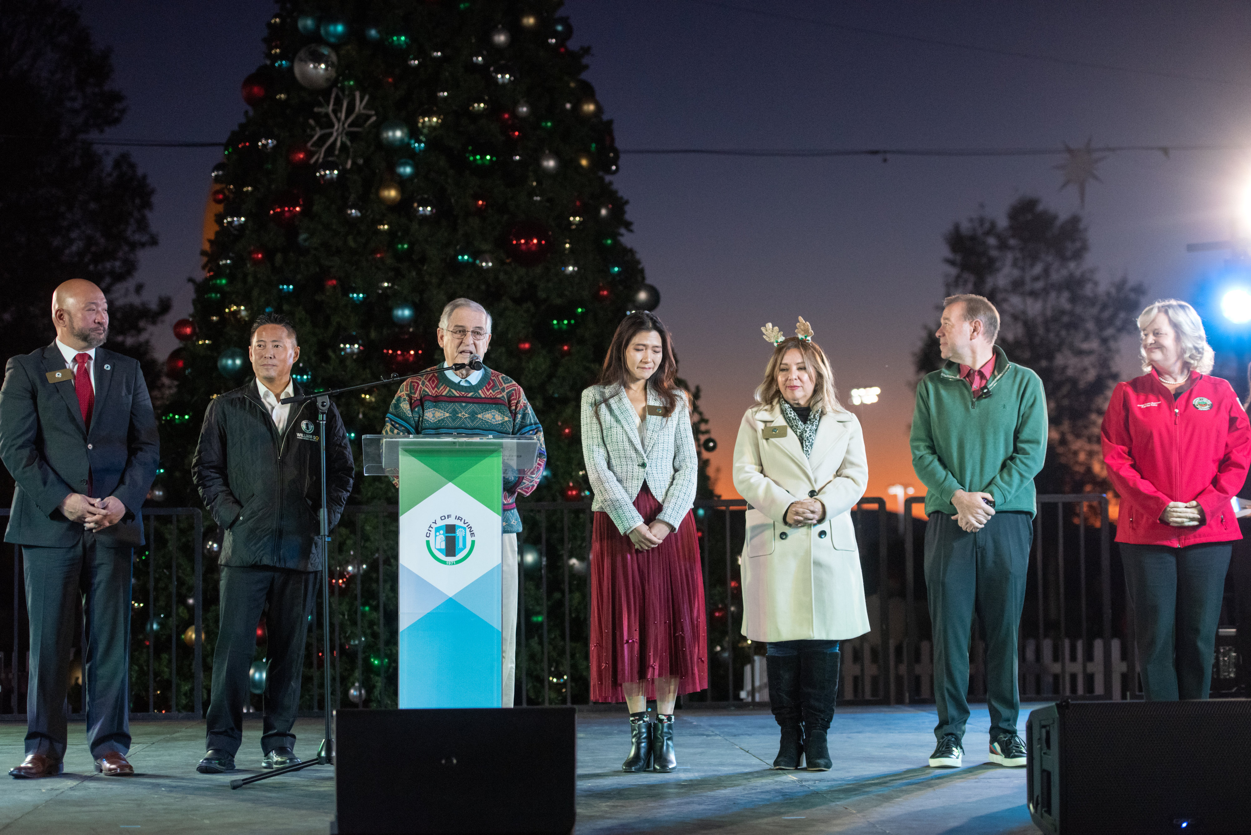 Irvine Mayor Larry Agran, at the podium, is joined by...