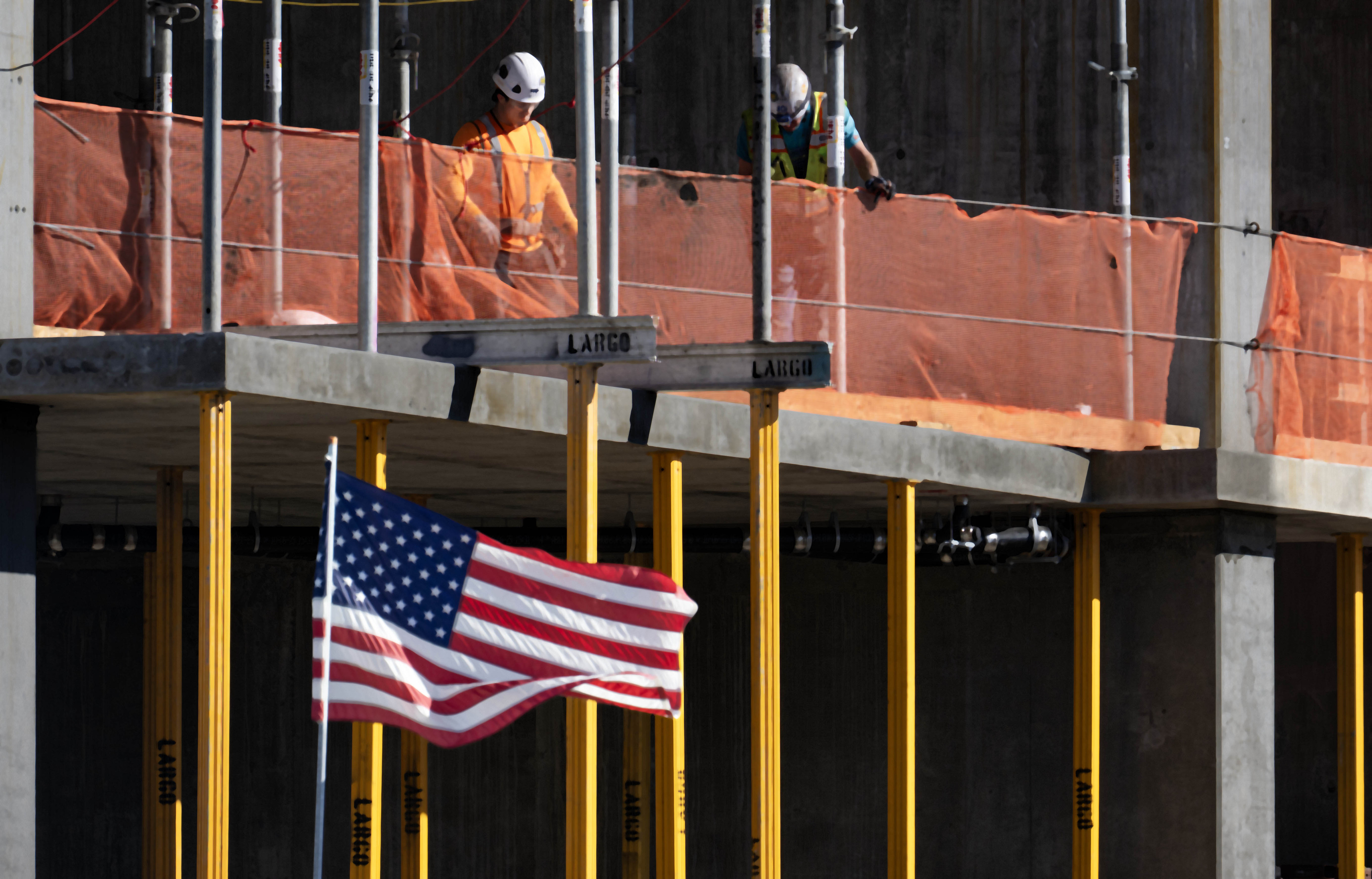 Old Glory flaps in the wind as construction for luxury...