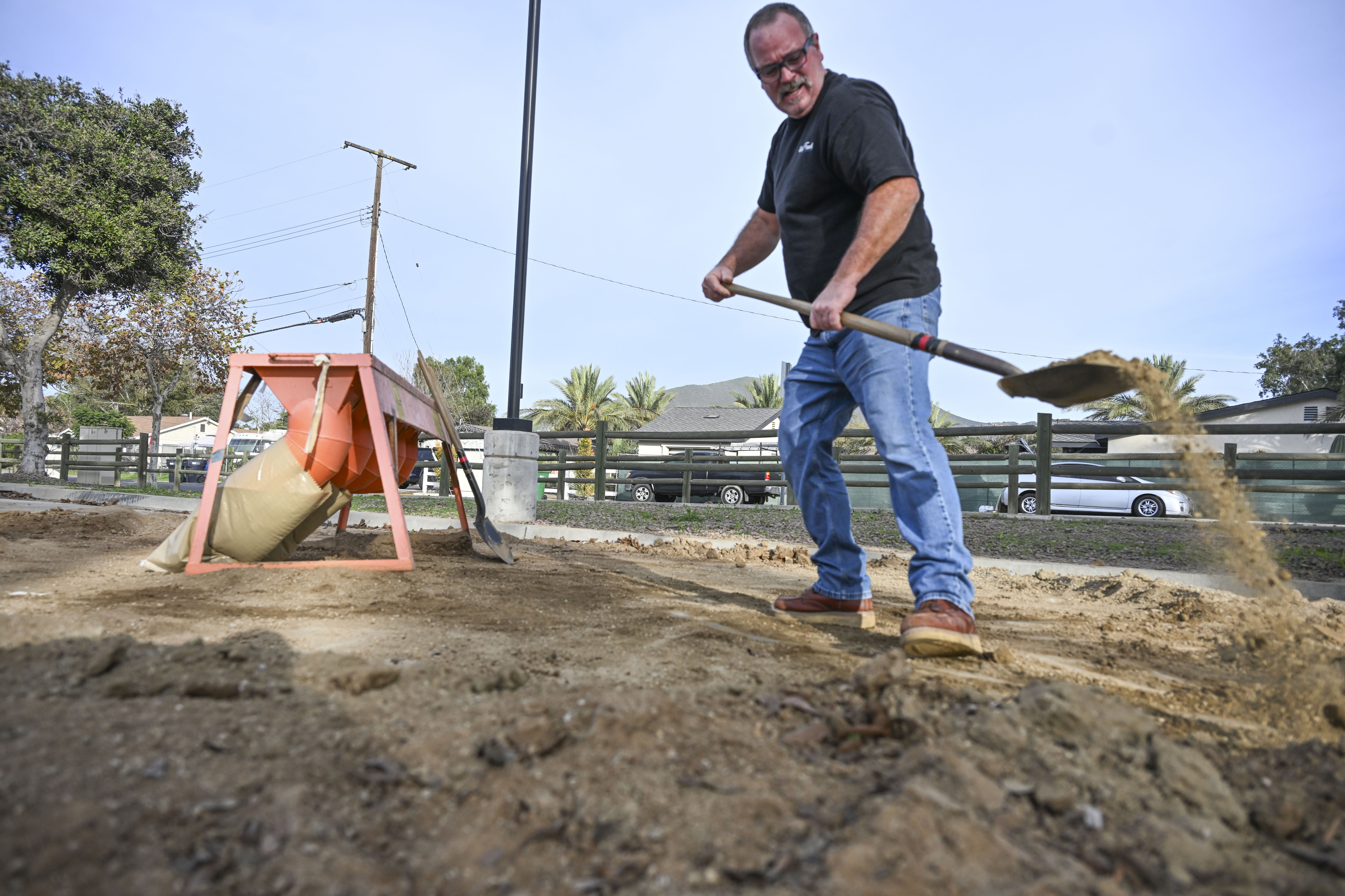 Norco resident Terry McCauley fills sandbags at a Riverside County...