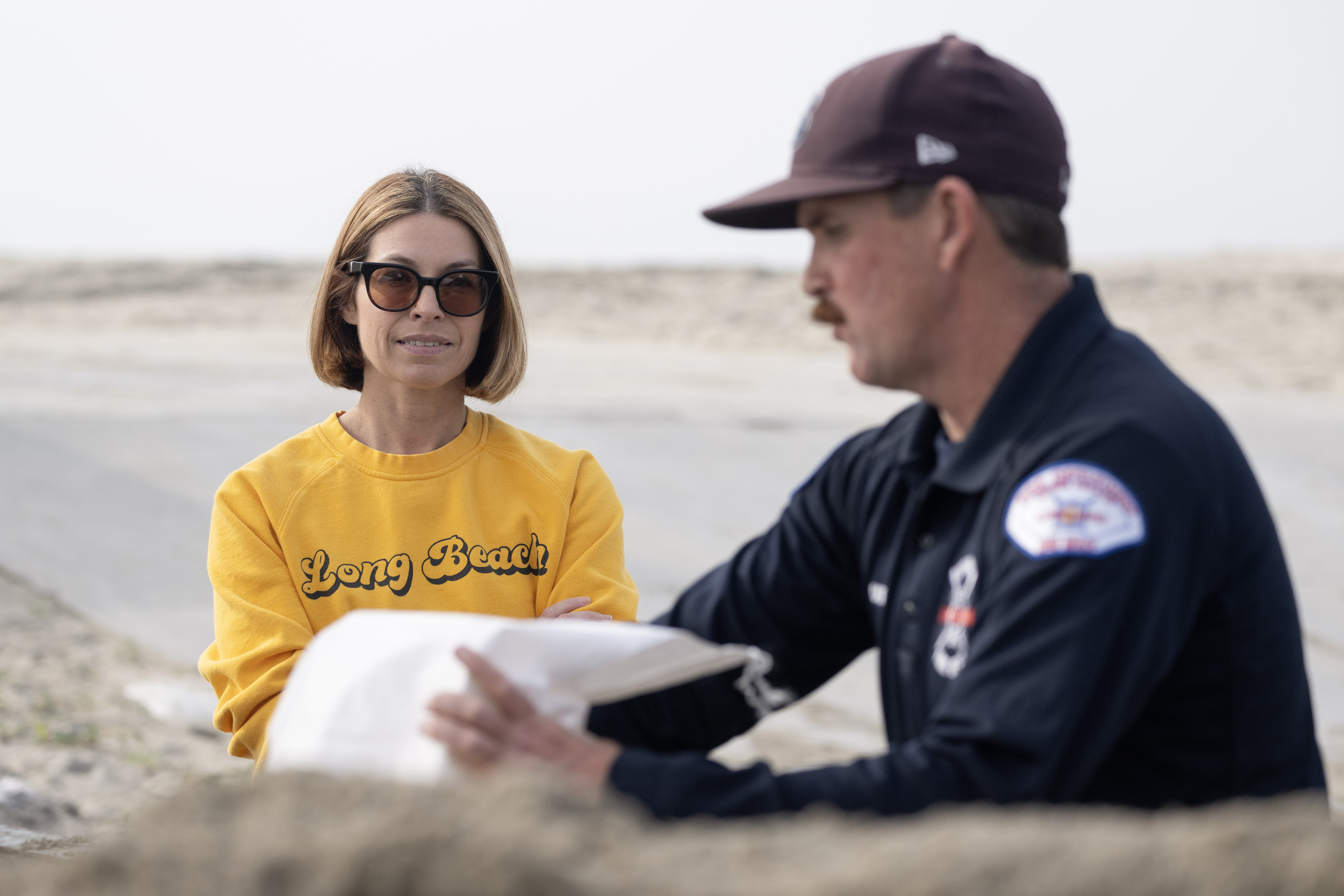 From right, Ocean Lifeguard Sean Guerin prepares sandbags for Kim...