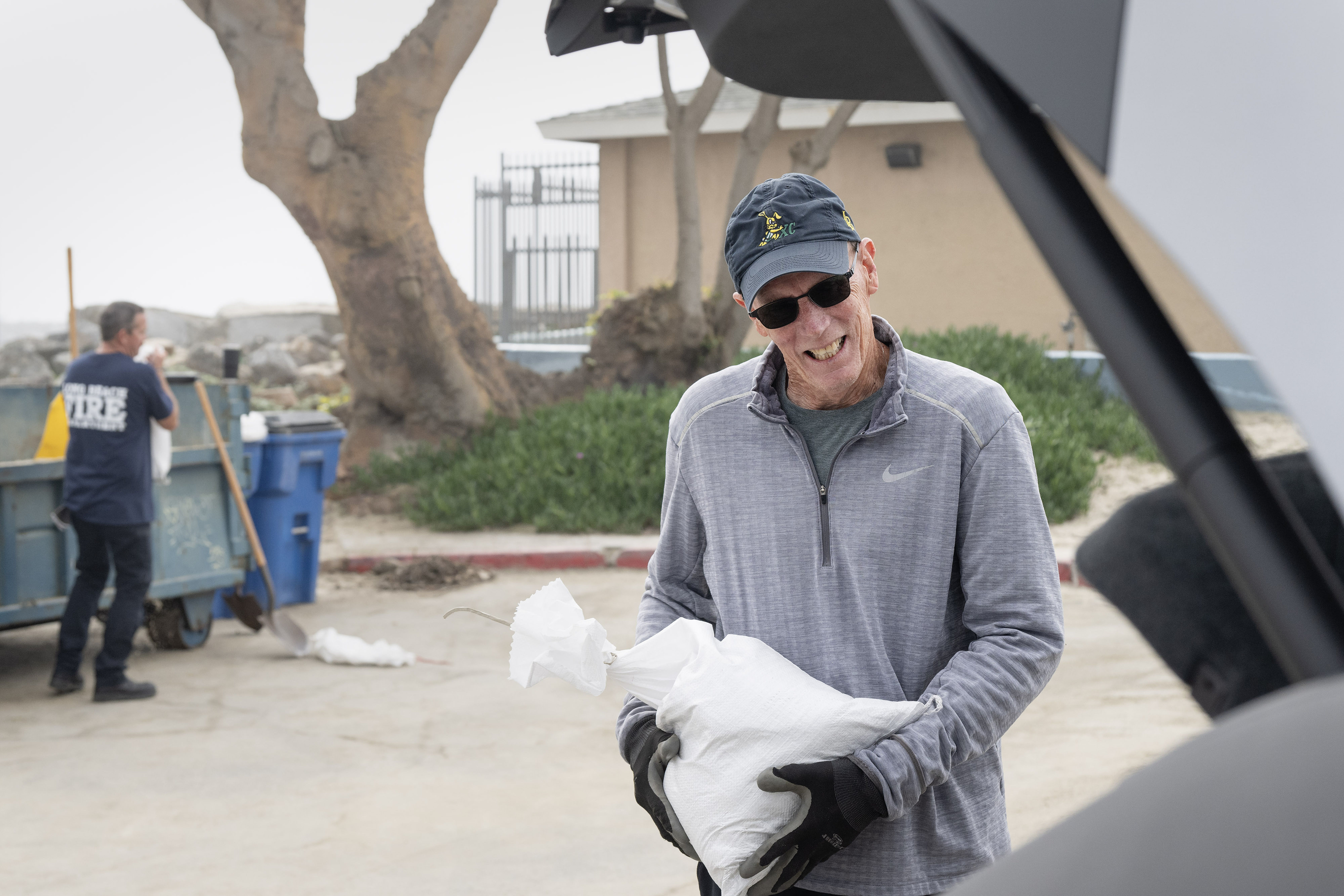 Joe Carlson loads sandbags to protect his home on the...