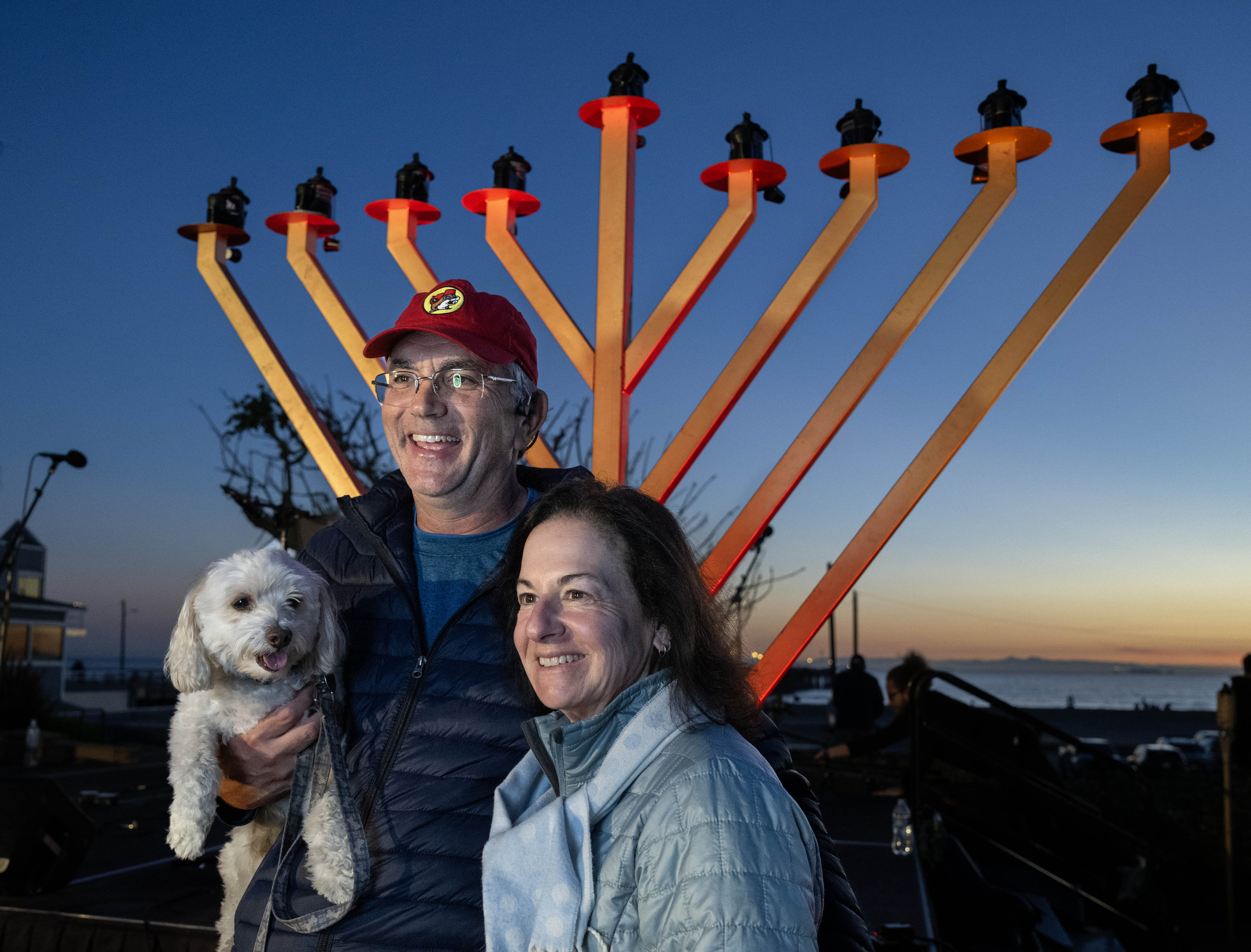 Gayle and Ian Chait take a picture with their dog,...